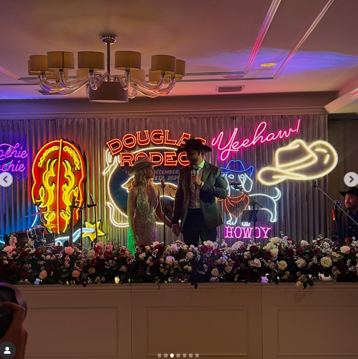 Will Douglas and his bride took the stage at their Western-themed celebration, featuring neon signage, as posted on January 1, 2025 | Source: Instagram/willdouglastx