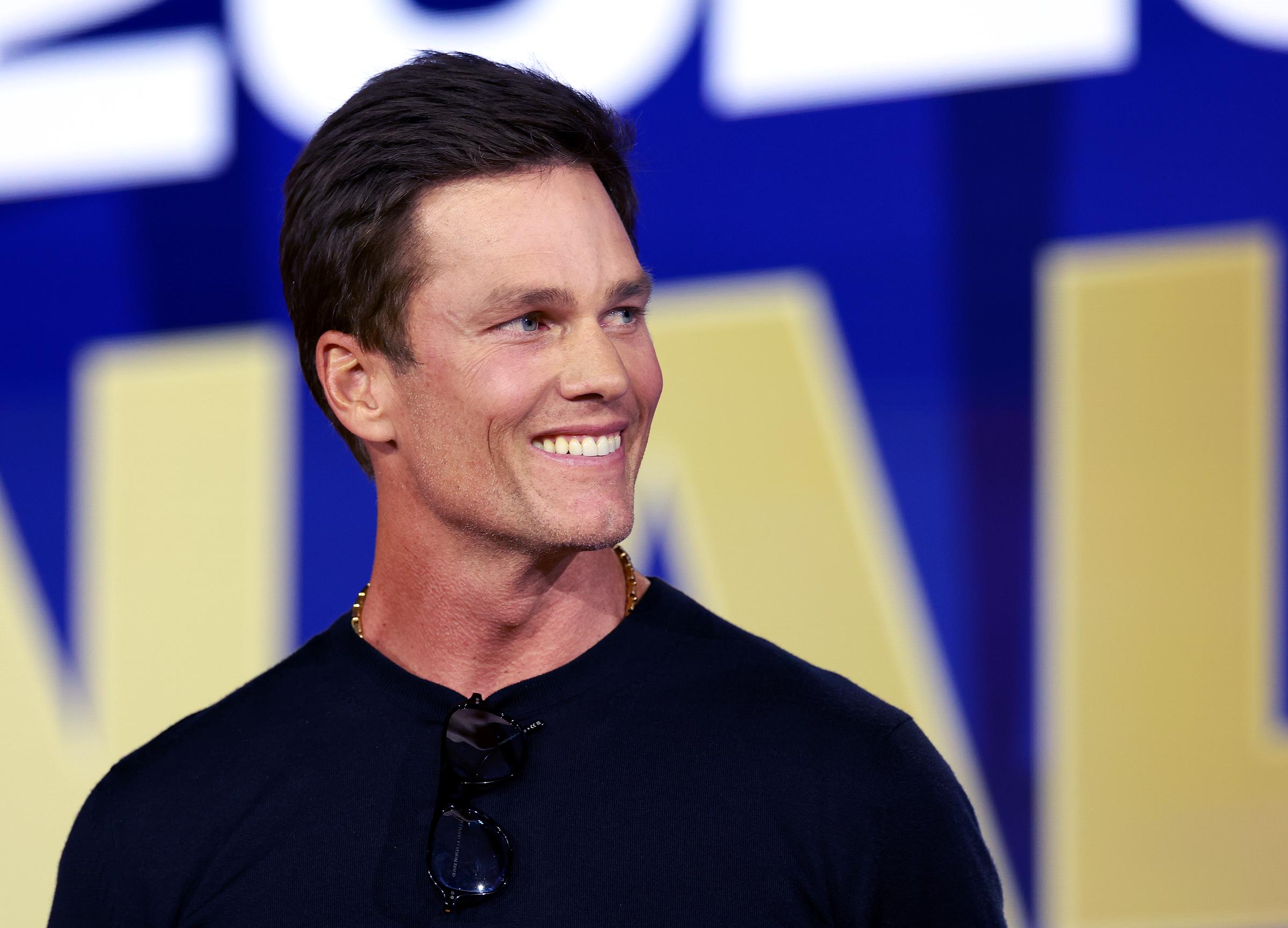 Tom Brady reacted during a press conference ahead of the FIFA World Cup 2026 final at Fanatics Fest in New York on July 17. The close-up emphasized his smooth complexion, prominent jawline, and defined cheekbones, features that have frequently been discussed as speculation surrounding his appearance has persisted.