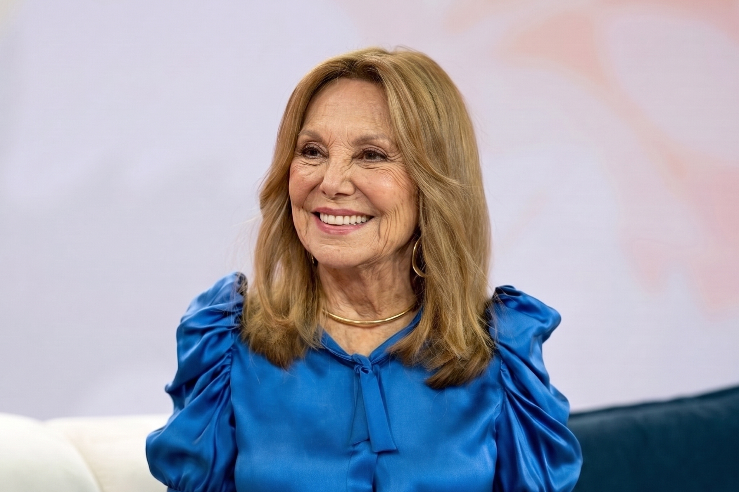 Marlo Thomas appears in an AI-generated studio portrait wearing a vibrant blue blouse. | Source: Nano Banana