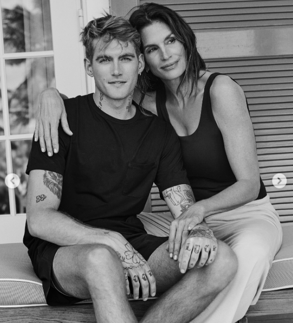 Cindy Crawford leaned in affectionately with her arm wrapped around son Presley Gerber in a tender black-and-white portrait posted on May 11, 2025, capturing the mother-son duo relaxing together outdoors as Presley showcased his hand and arm tattoos. | Source: Instagram/cindycrawford