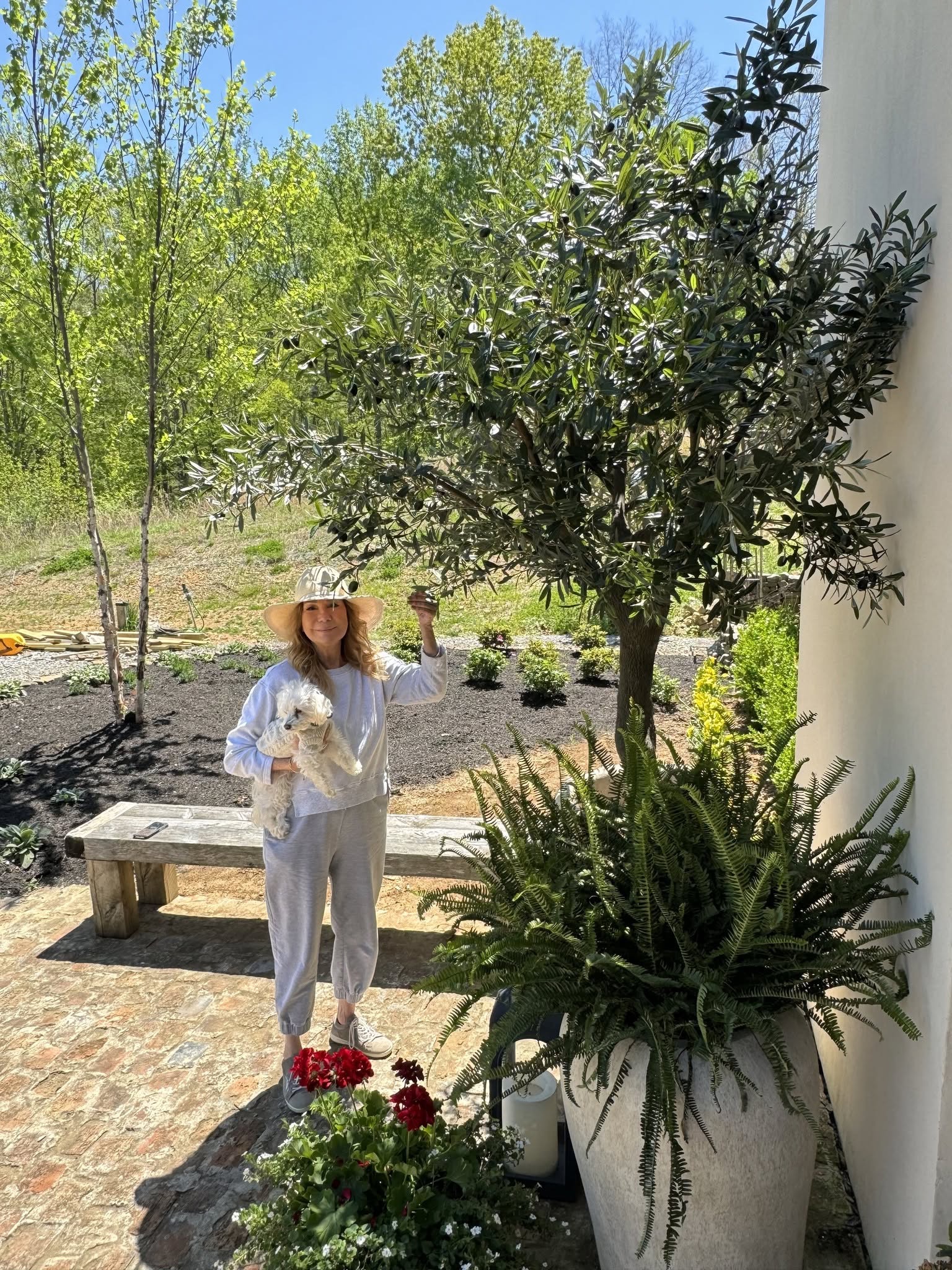 Kathie Lee enjoys a sunny afternoon in the garden of her Nashville home, holding her beloved little dog beside an olive tree — a glimpse of the peaceful life she has embraced in Tennessee. | Source: Kathie Lee Gifford's Facebook.