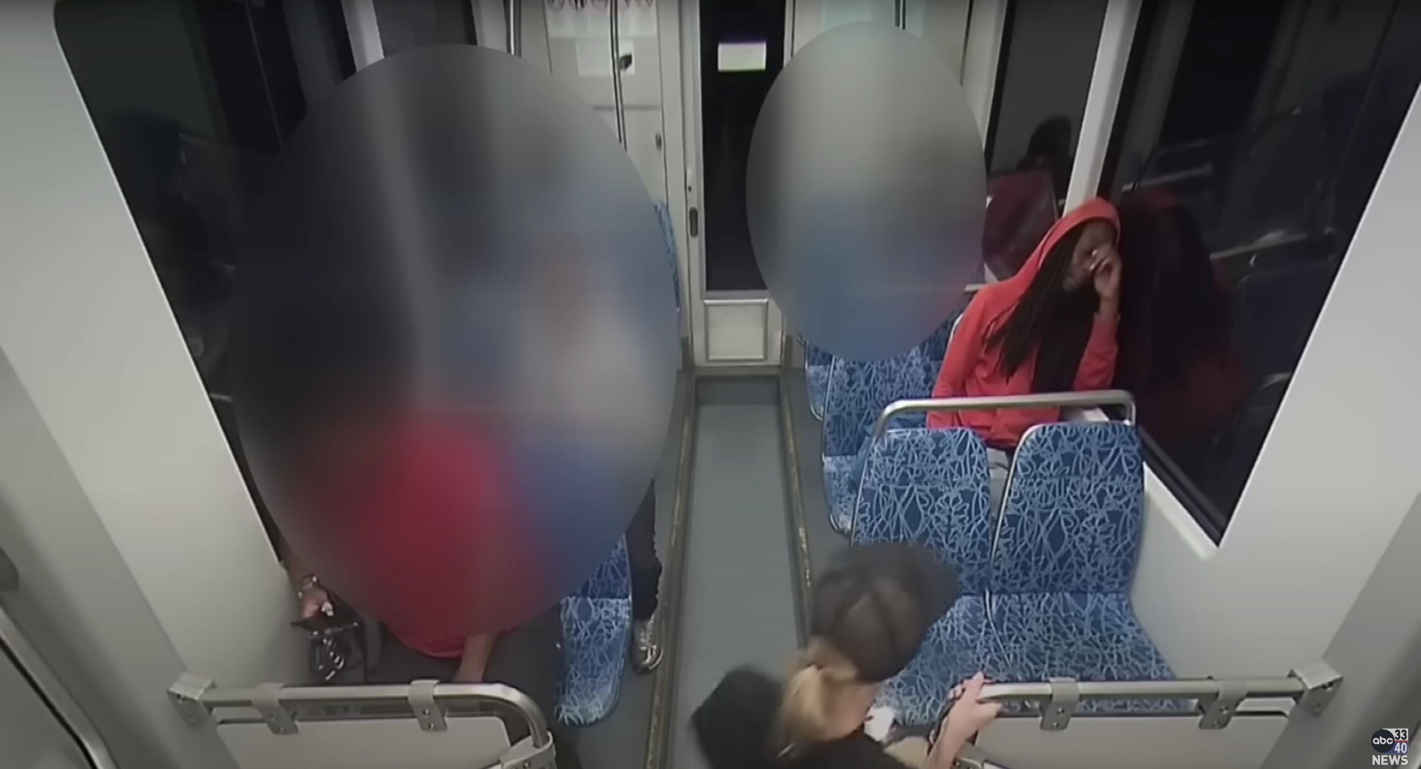 Iryna Zarutska (bottom, in black shirt) is seen taking a seat in front of Decarlos Brown (right, in red hoodie), as posted on September 9, 2025 | Source: YouTube/abc3340