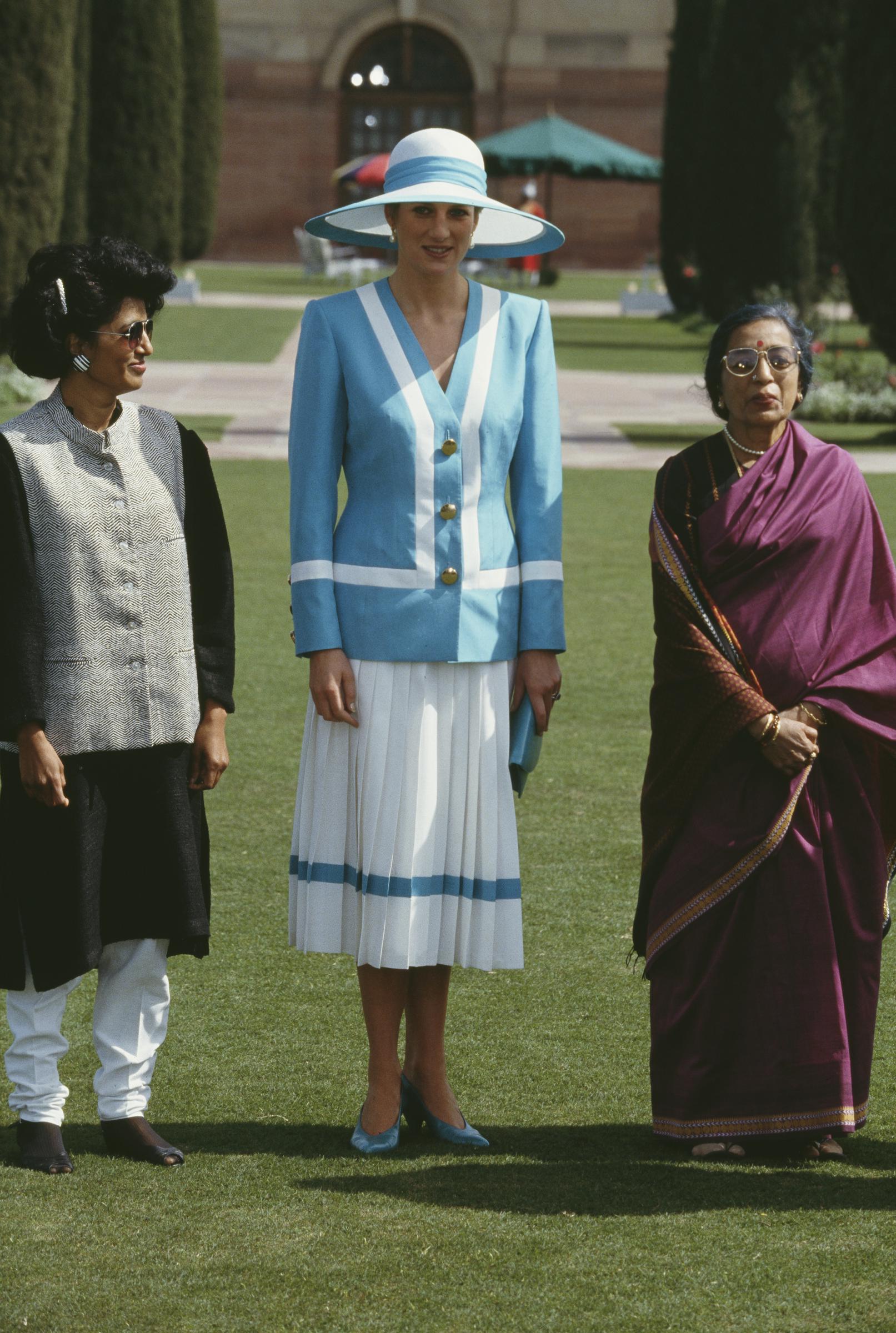 Princess Diana stands alongside Janaki Venkataraman, wife of the Indian President, at Rashtrapati Bhavan on February 12, 1992. In her blue and white ensemble, Diana exudes diplomatic elegance, while the women share a composed moment against the backdrop of India’s grand presidential palace.