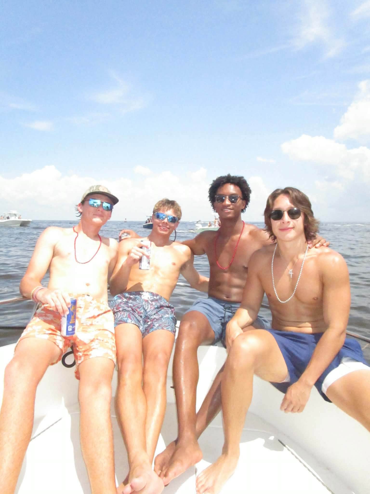 The 18-year-old college football player relaxes on the bow alongside his three companions. The group traveled by boat to Horn Island to celebrate the holiday weekend. | Source: Facebook/christine.wonsley
