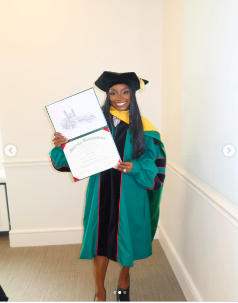 Simone Biles posing with her honorary degree from Washington University. | Source: Instagram/simonebiles