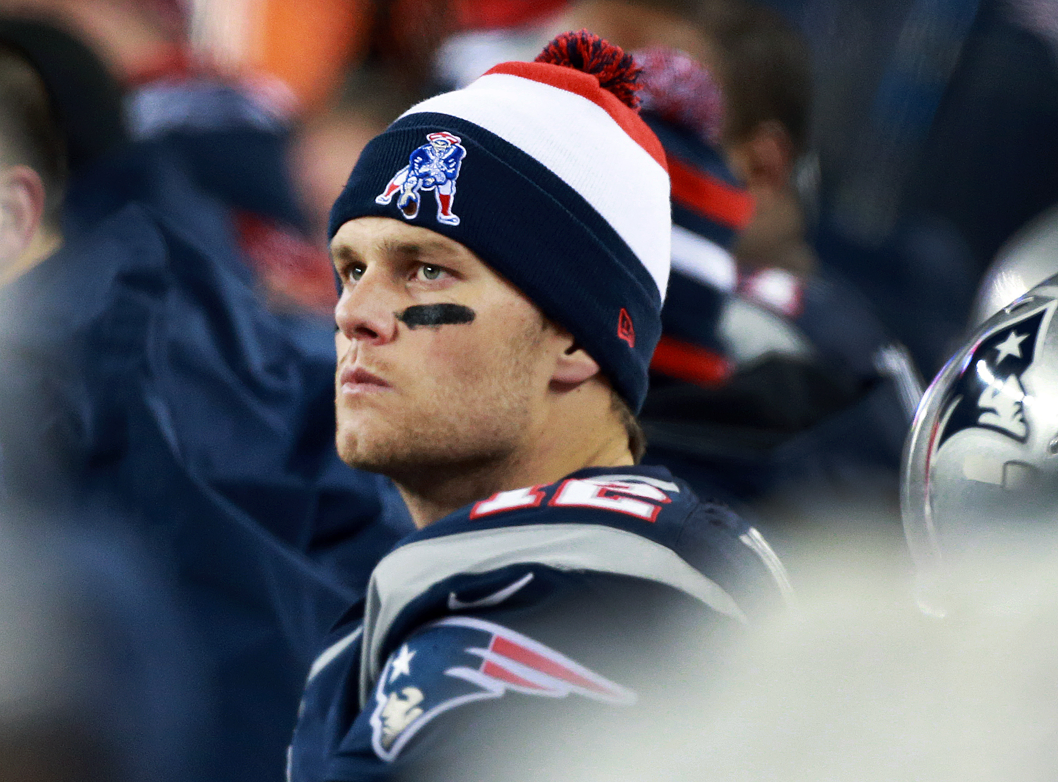 Tom Brady is pictured on the bench late in the game during the AFC Championship matchup between the New England Patriots and the Baltimore Ravens at Gillette Stadium. With an intense gaze, he watches the field, focused on the game.
