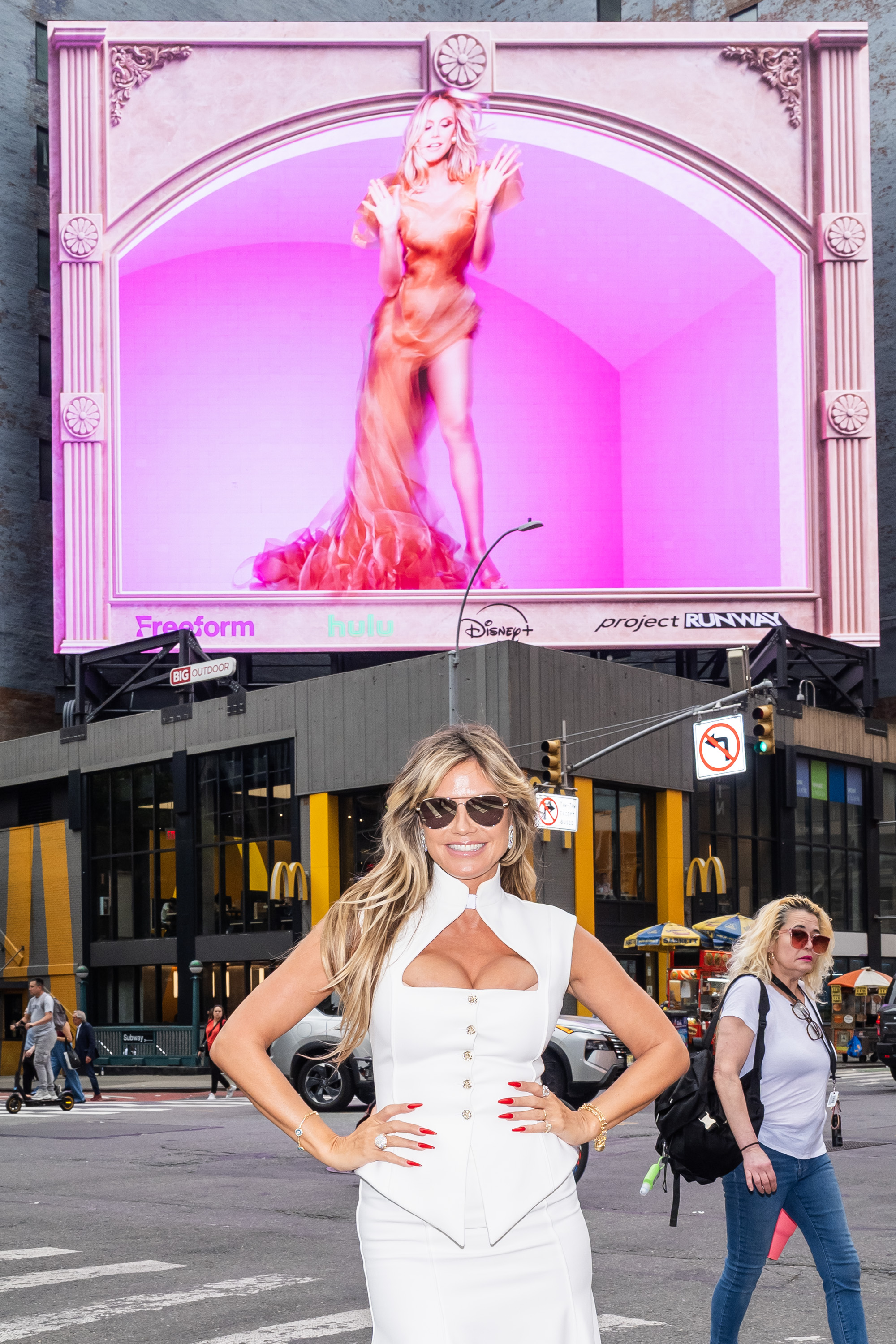 Heidi Klum smiles while standing beneath her "Project Runway" billboard in Times Square on August 6, 2025, in New York City | Source: Getty Images