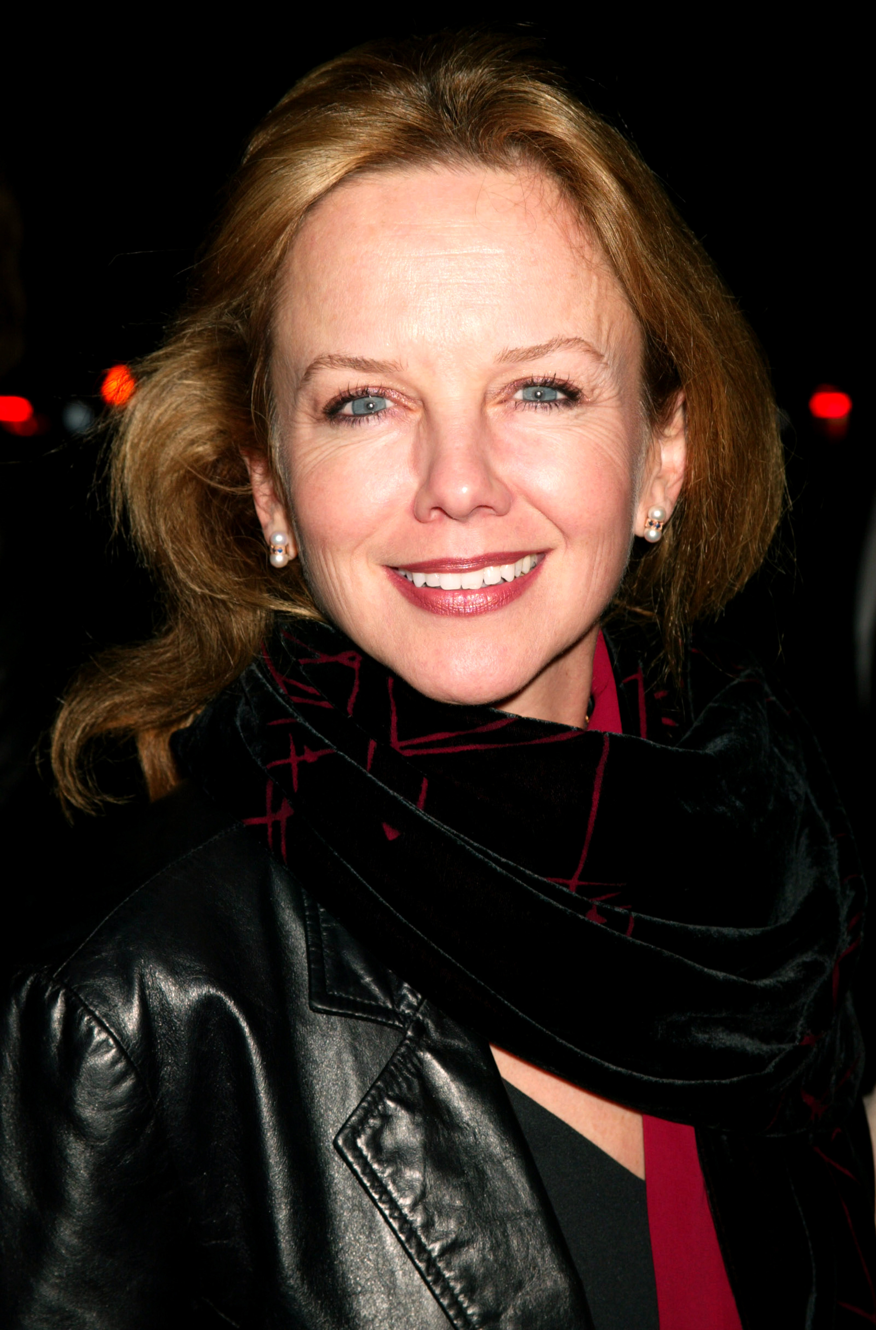 Arriving at the premiere of "Evelyn" on December 3, 2002, 47-year-old Linda Purl embraced the distinct elegance of her late 40s with defined expression lines and deepening crow's feet that brought warmth to her signature smile. Her golden-brown tresses were swept back to accentuate her timeless features, styled alongside luminous pearl drop earrings, a dramatic black velvet patterned scarf, and a sleek leather jacket.