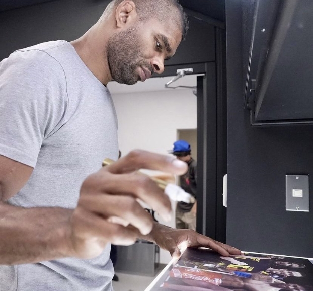 A closer view captured Alistair Overeem signing a piece of memorabilia, with the short sleeves of his gray T-shirt revealing the dramatic reduction in size through his upper body. Although his athletic build remained visible, his arms and shoulders appeared notably leaner than in photographs from his years competing as a heavyweight. The change came as Overeem adopted a new nutritional regimen, changed his eating habits, and prepared to move beyond a fighting career that had spanned 25 years. | Source: X/COMBAT SPORTS TODAY