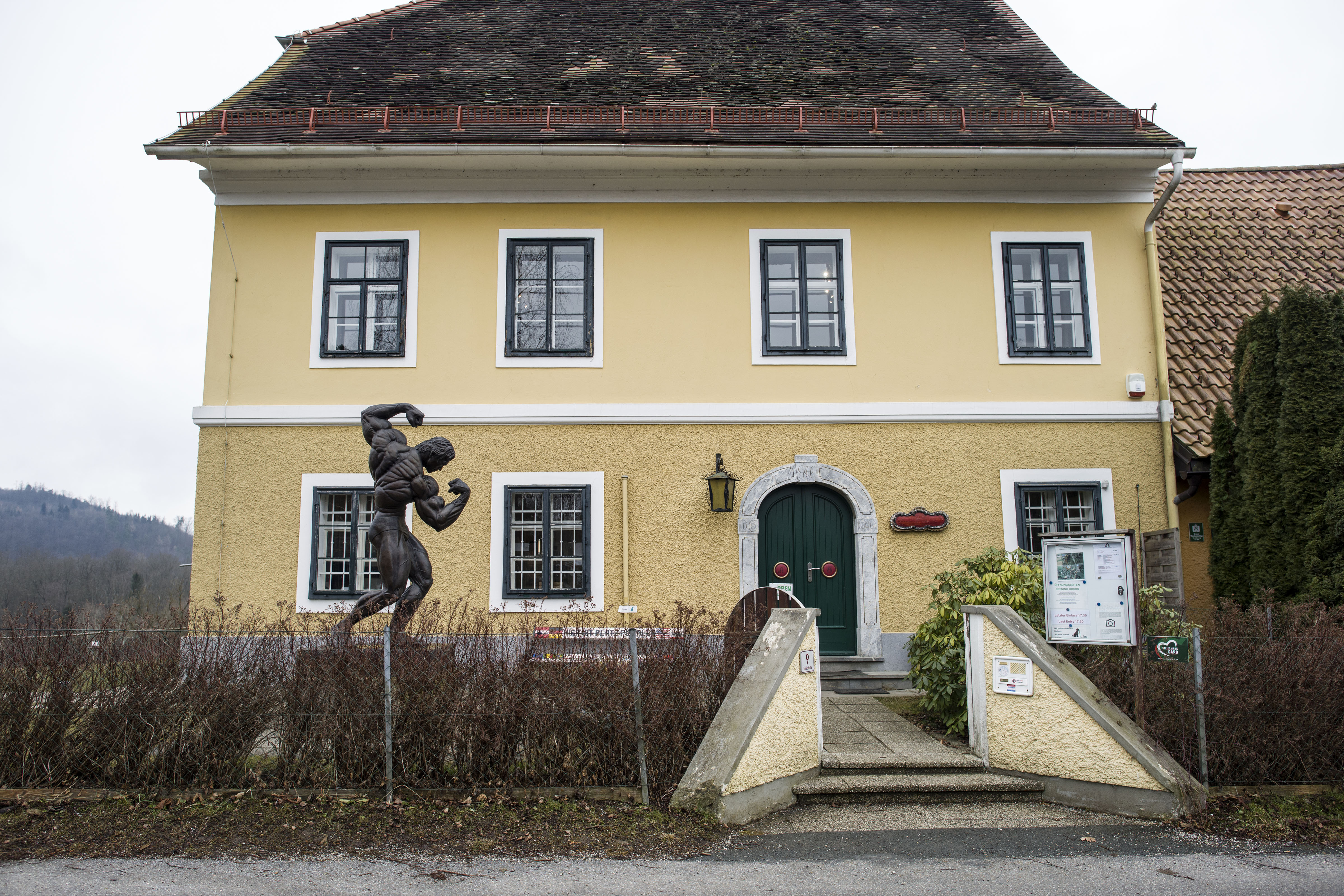 A statue of Schwarzenegger striking his signature bodybuilding pose stands outside the home where his journey began. Since opening as a museum in 2011, the property has welcomed visitors from around the world who want to trace his path from a small Austrian village to international fame. | Source: Getty Images