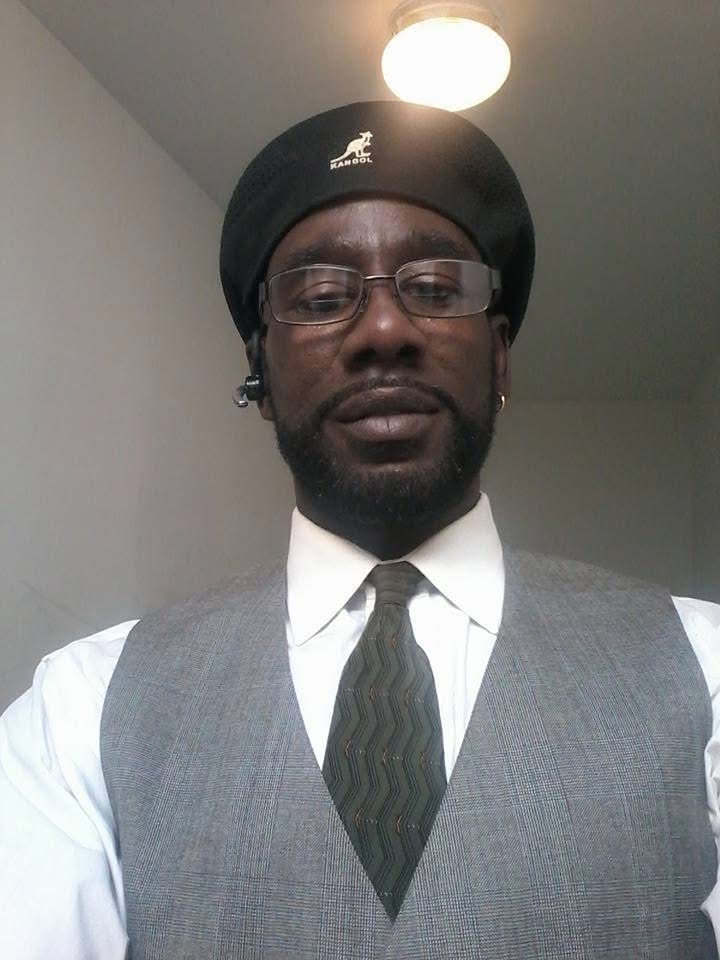 Keith McAllister in a white collared shirt, dark tie, gray vest and black beret. | Source: GoFundMe
