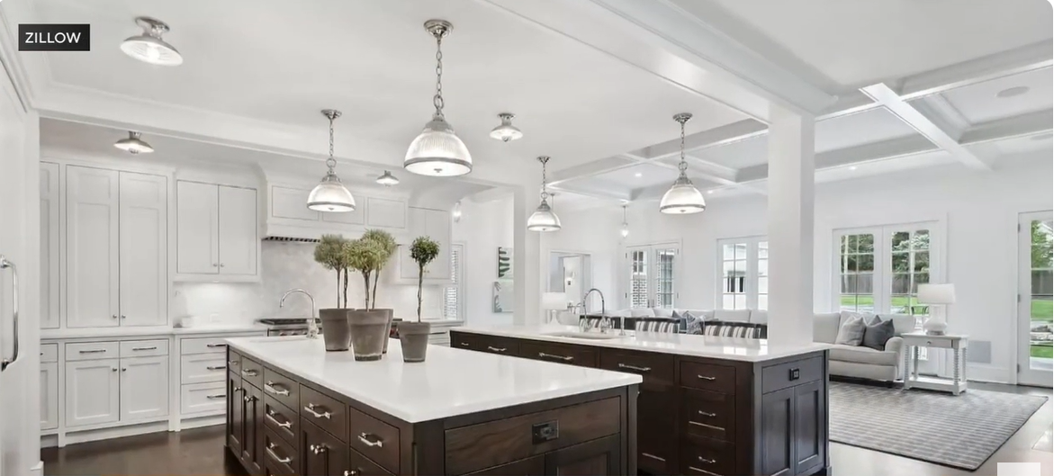 The famous “Home Alone” kitchen now features a bright, open-concept design with sleek white cabinetry and contrasting dark wood islands. Modern pendant lights add a touch of elegance, while natural light pours in from wide windows. The space exudes sophistication and warmth, blending luxury with family comfort. | Source: YouTube/CBSChicago