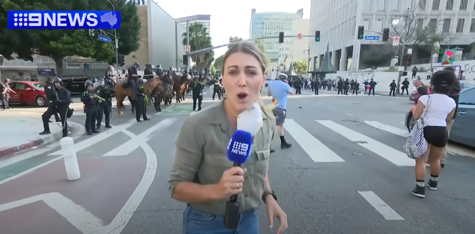 Lauren Tomasi reporting from Downtown Los Angeles during confrontations between the U.S. National Guard and protestors on June 8, 2025 | Source: Youtube/9 News Australia