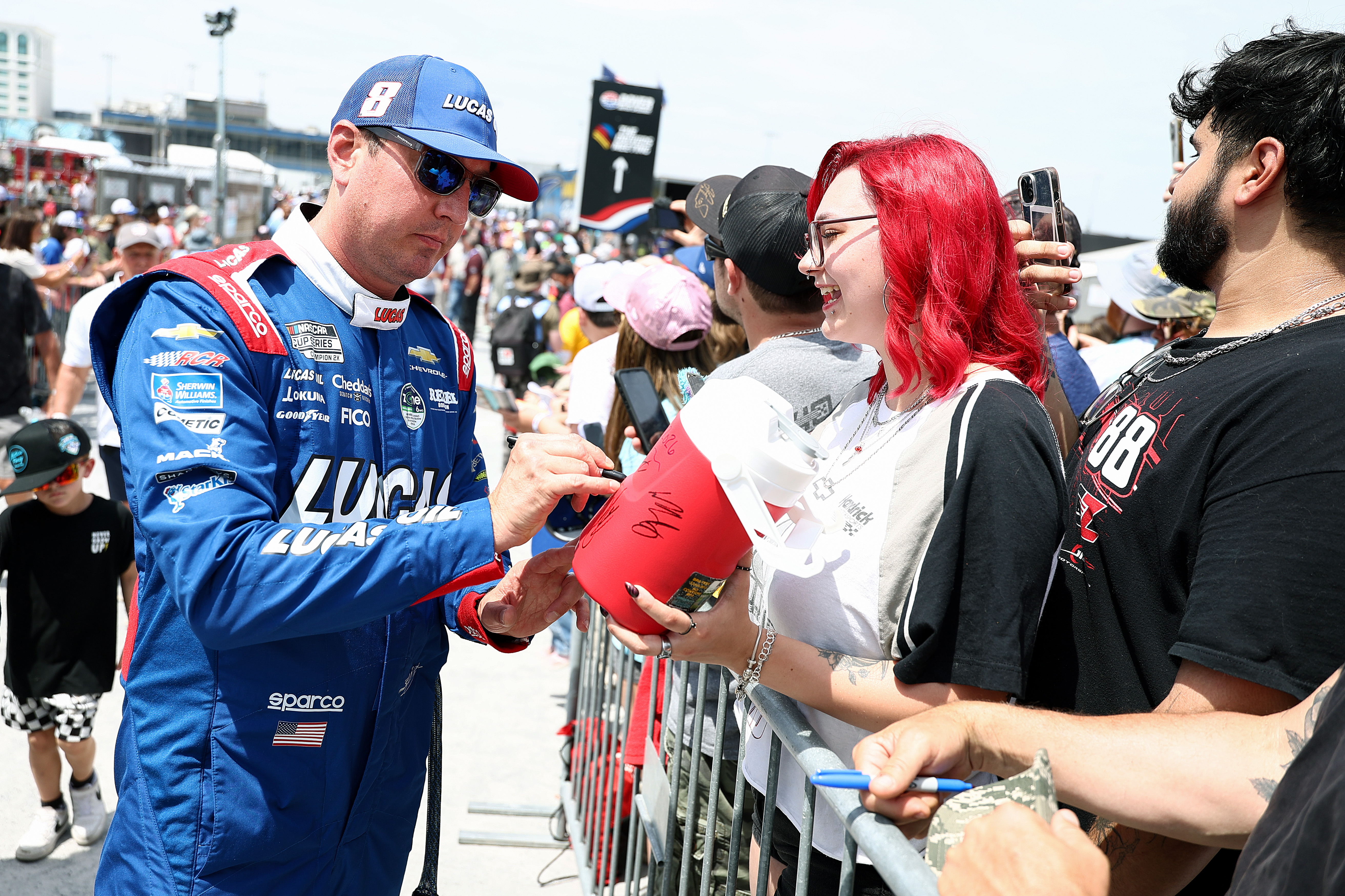 Kyle Busch signing autographs for fans at the NASCAR Cup Series All-Star Race. | Source: Getty Images