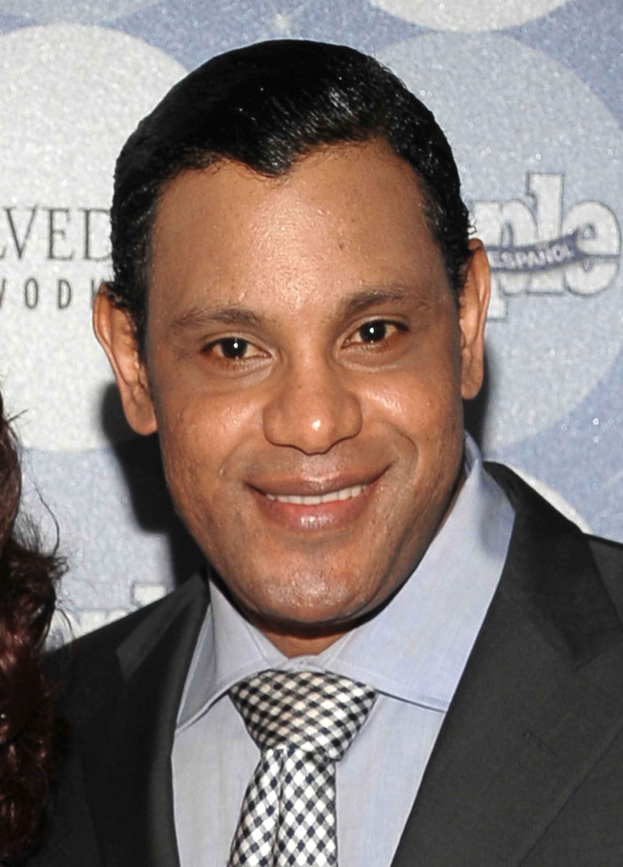 Sammy Sosa smiled for photographers at People en Español's Los 50 Más Bellos party at Gustavino's in New York City on May 20, 2010. Wearing a dark suit, light blue shirt, and patterned tie, Sosa attended the event several years after his final MLB season, during a period when his noticeably lighter complexion had increasingly drawn public attention and prompted discussion about the changes in his appearance.