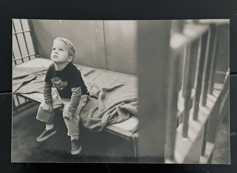 A young Deacon sits for a candid black-and-white portrait, looking upward as he perches on the edge of a bed. The childhood image offers an early glimpse of Reese and Ryan's son years before his own entertainment career began. | Source: Instagram/Deaconphillippe