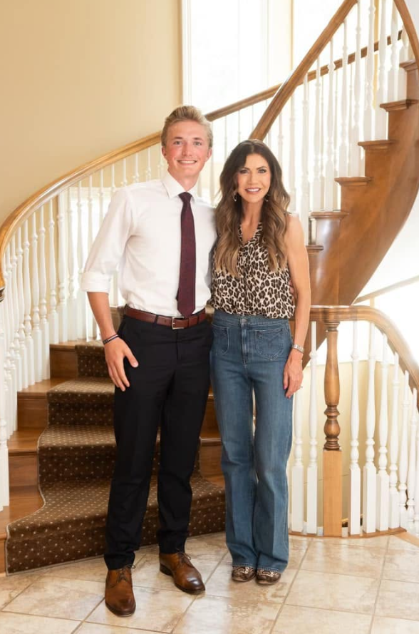 Inside the residence, the curved staircase is one of the most prominent architectural features. Wood steps and railings are paired with white spindles and a patterned runner. | Source: Facebook/kristi.noem