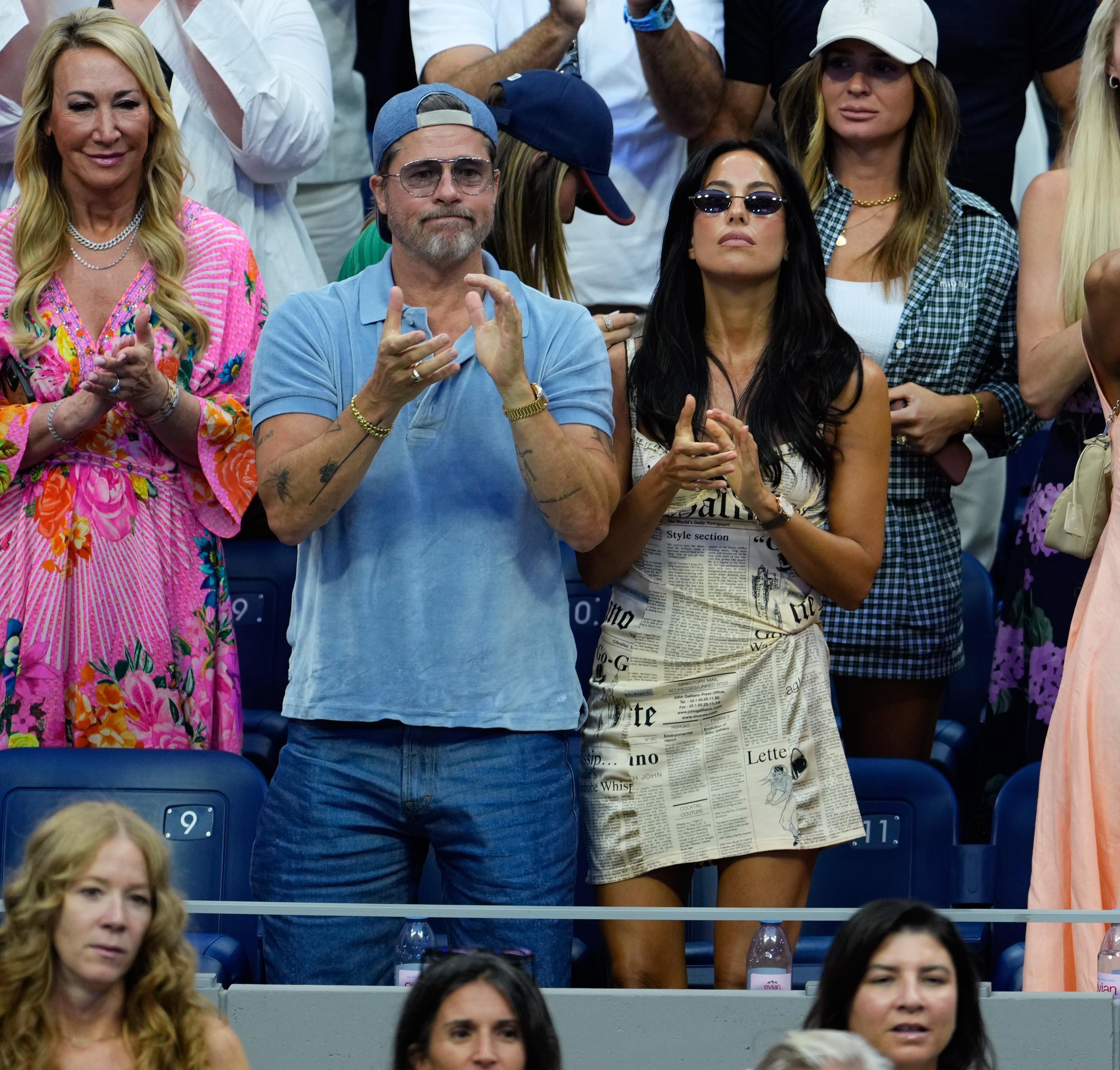 Pitt kept his Day 14 look casual in a light blue short-sleeved polo and medium-wash jeans. He added a backward blue baseball cap and navy blue gradient sunglasses.