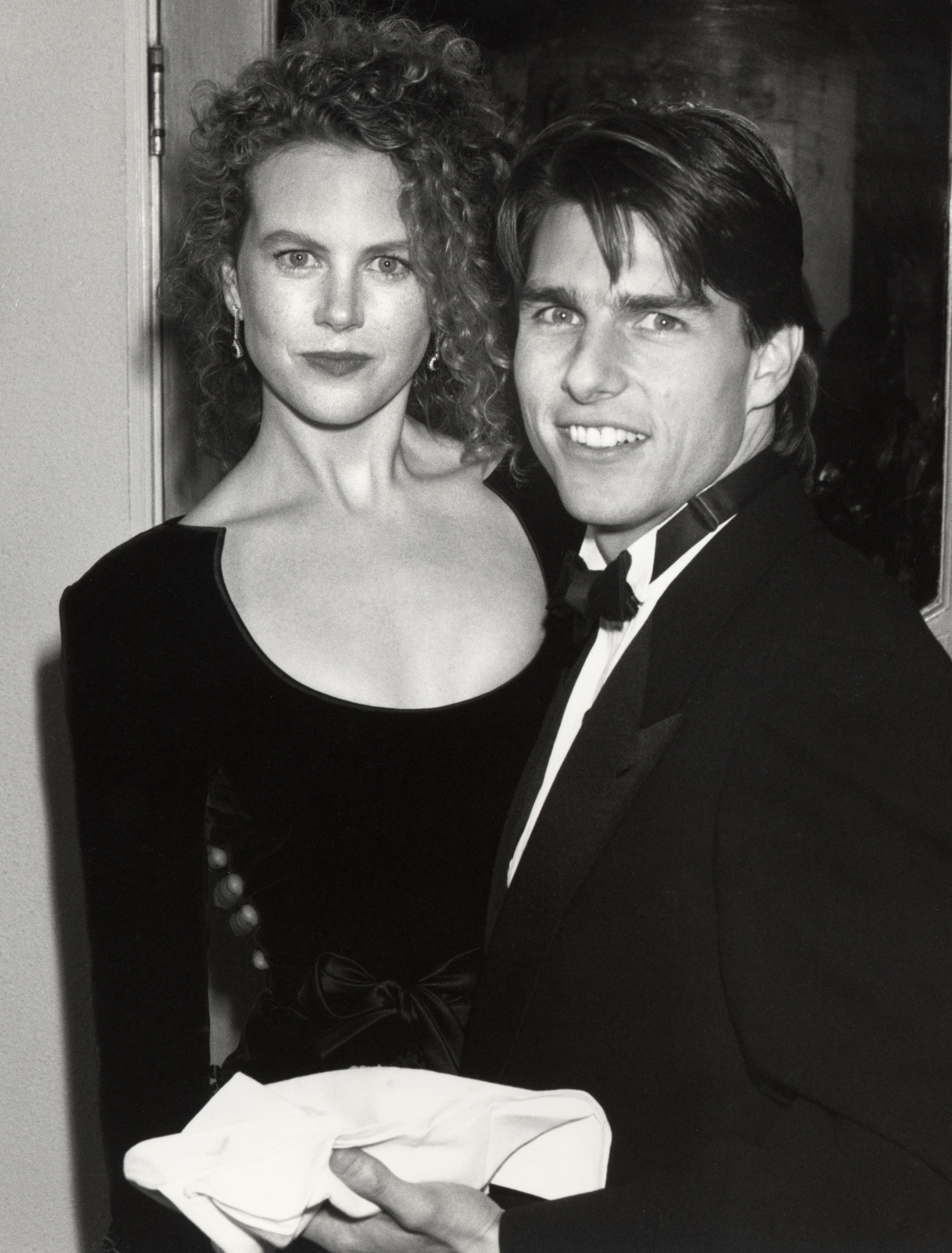 Standing alongside Tom Cruise at the 1991 Academy Awards, this moment captures the peak of her early, natural facial volume. This soft, rounded structure defines the baseline of her visual timeline before any public speculation regarding red carpet transformations began. | Source: Getty Images