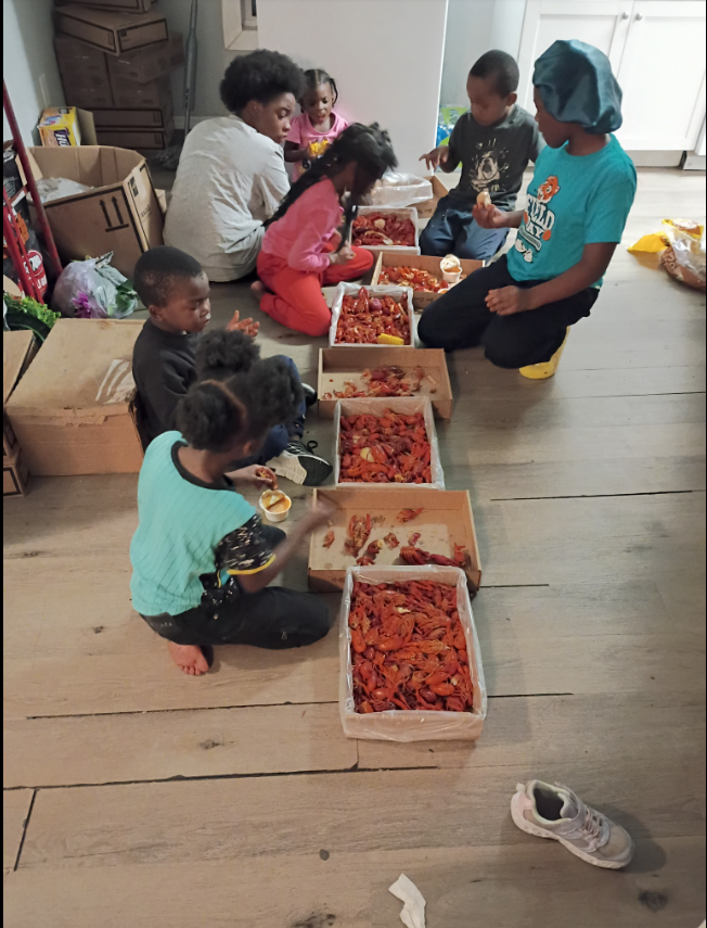 A candid moment of togetherness: Shamar Elkins's children gather on the floor, laughing and focused, as they dig into trays of bright red crawfish. | Source: Facebook/Shamar Elkins