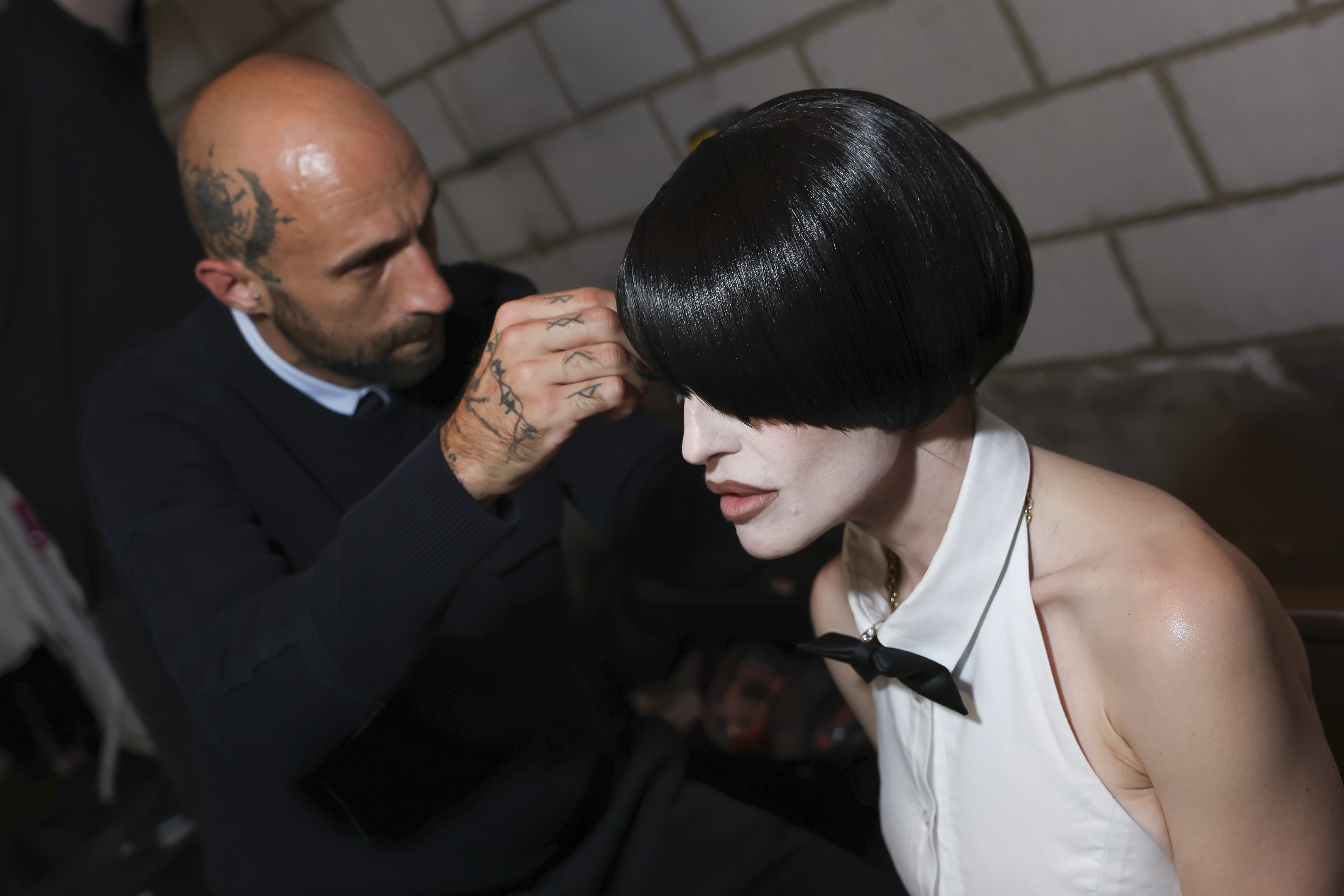 A stylist adjusts Kelly Osbourne's glossy black bob wig backstage ahead of the Natasha Zinko show at Collins Music Hall in London on September 18, 2026. | Source: Getty Images