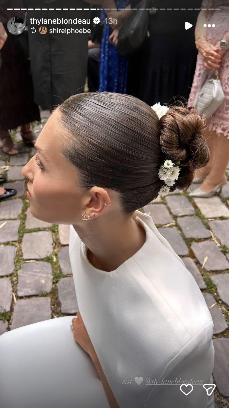 Blondeau completed her minimalist bridal look with a polished bun accented by delicate white flowers. | Source: Instagram/thylaneblondeau
