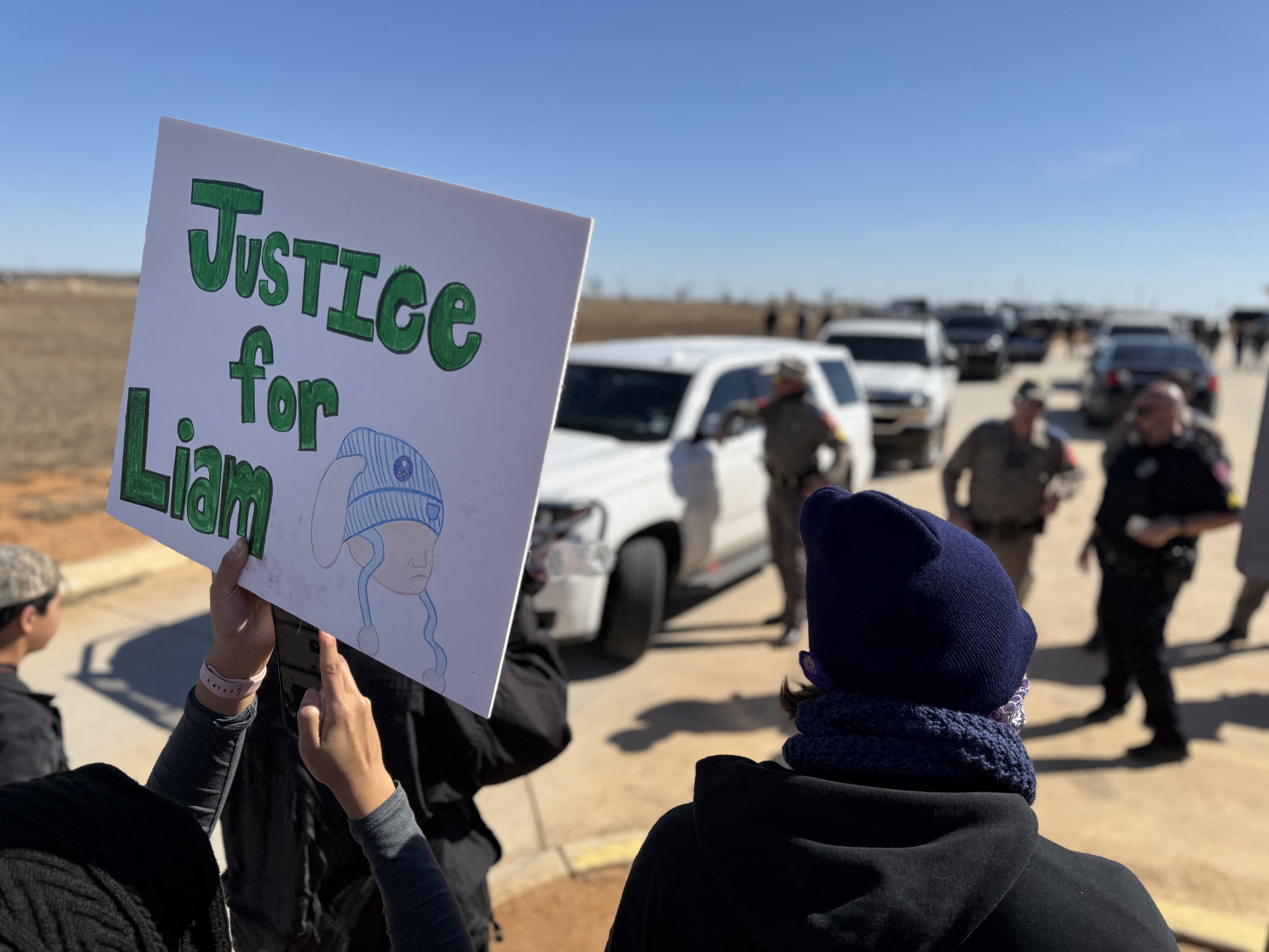 Protesters gather outside a Texas detention center holding signs in support of a detained child on January 28, 2026 | Source: Getty Images
