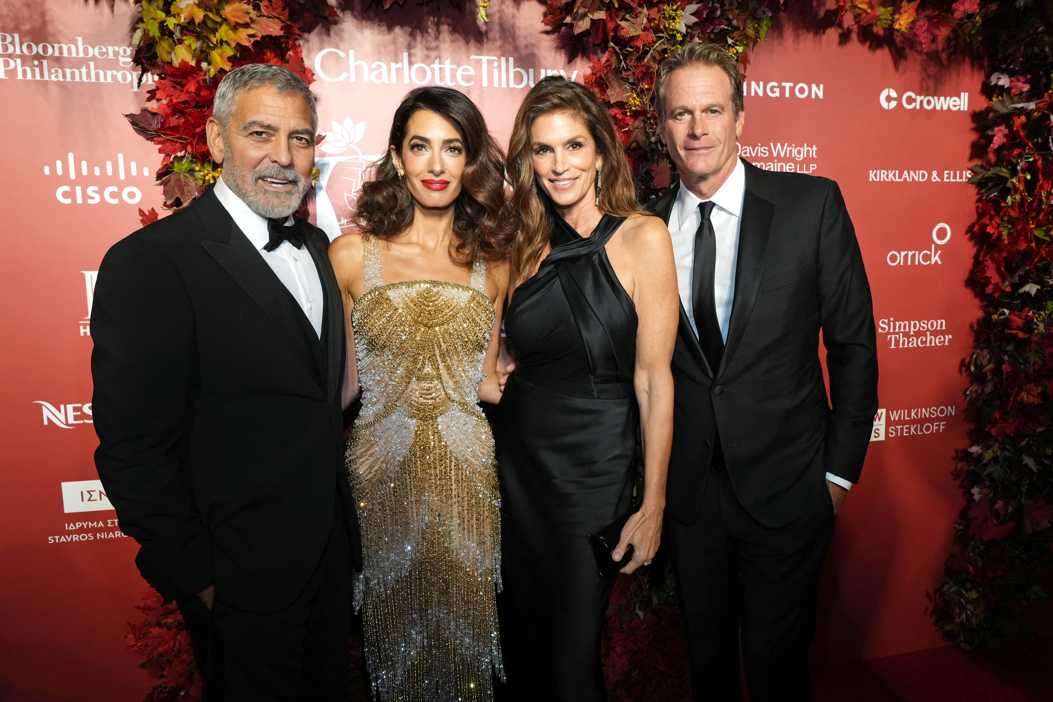 Double-date glamour took over the New York Public Library as George Clooney, Amal Clooney, Cindy Crawford, and Rande Gerber gathered for the Clooney Foundation For Justice Inaugural Albie Awards on September 29, 2022, in New York City. The power couples posed together in striking black-tie style: George and Rande looked polished in sharp black suiting, while Amal dazzled in a shimmering gold beaded fringe gown beside Cindy, who stunned in an elegant draped black dress. | Source: Getty Images