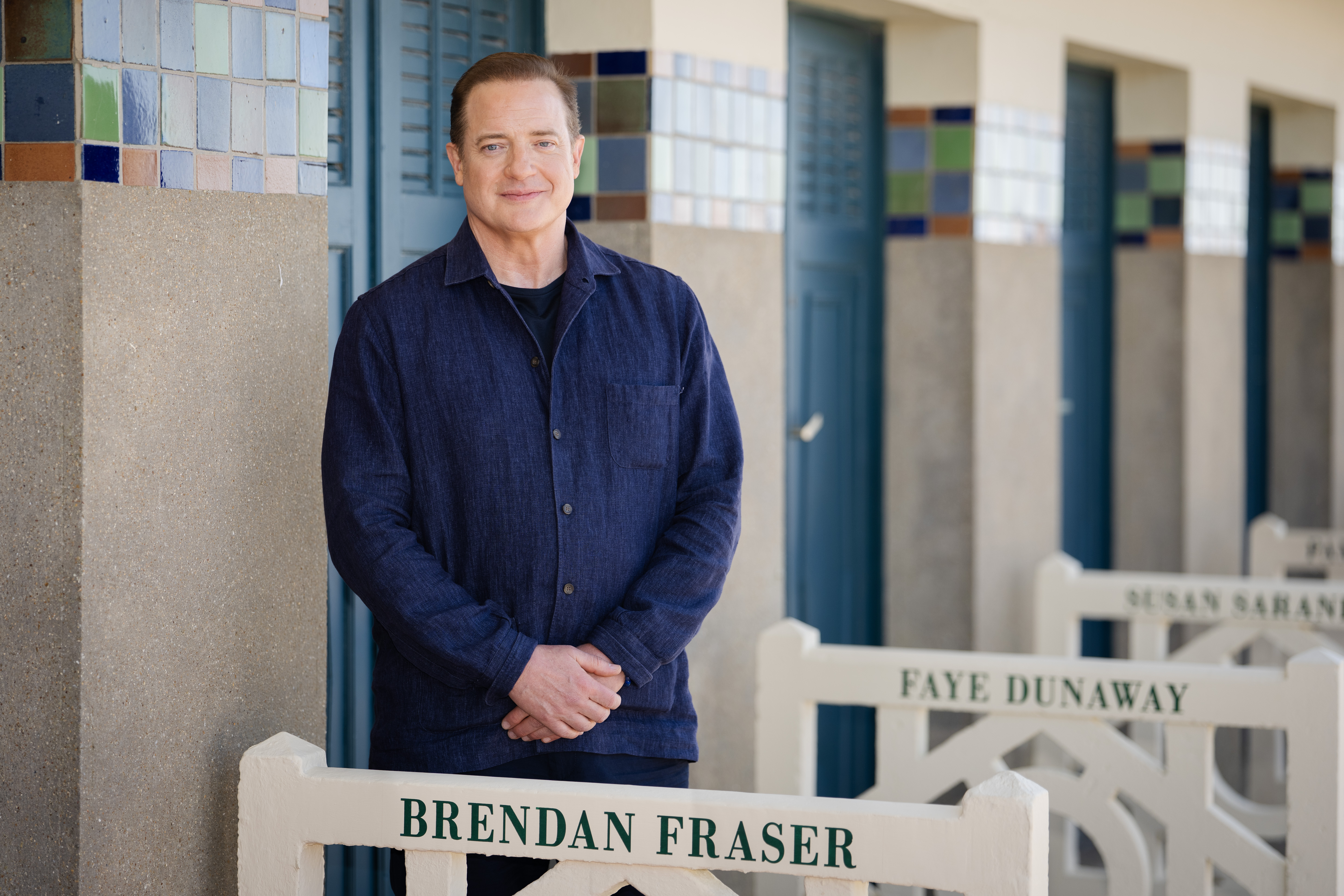 Brendan Fraser poses beside a director's chair bearing his name at the 2025 Cannes Film Festival, marking another chapter in his remarkable Hollywood comeback. | Source: Getty Images.