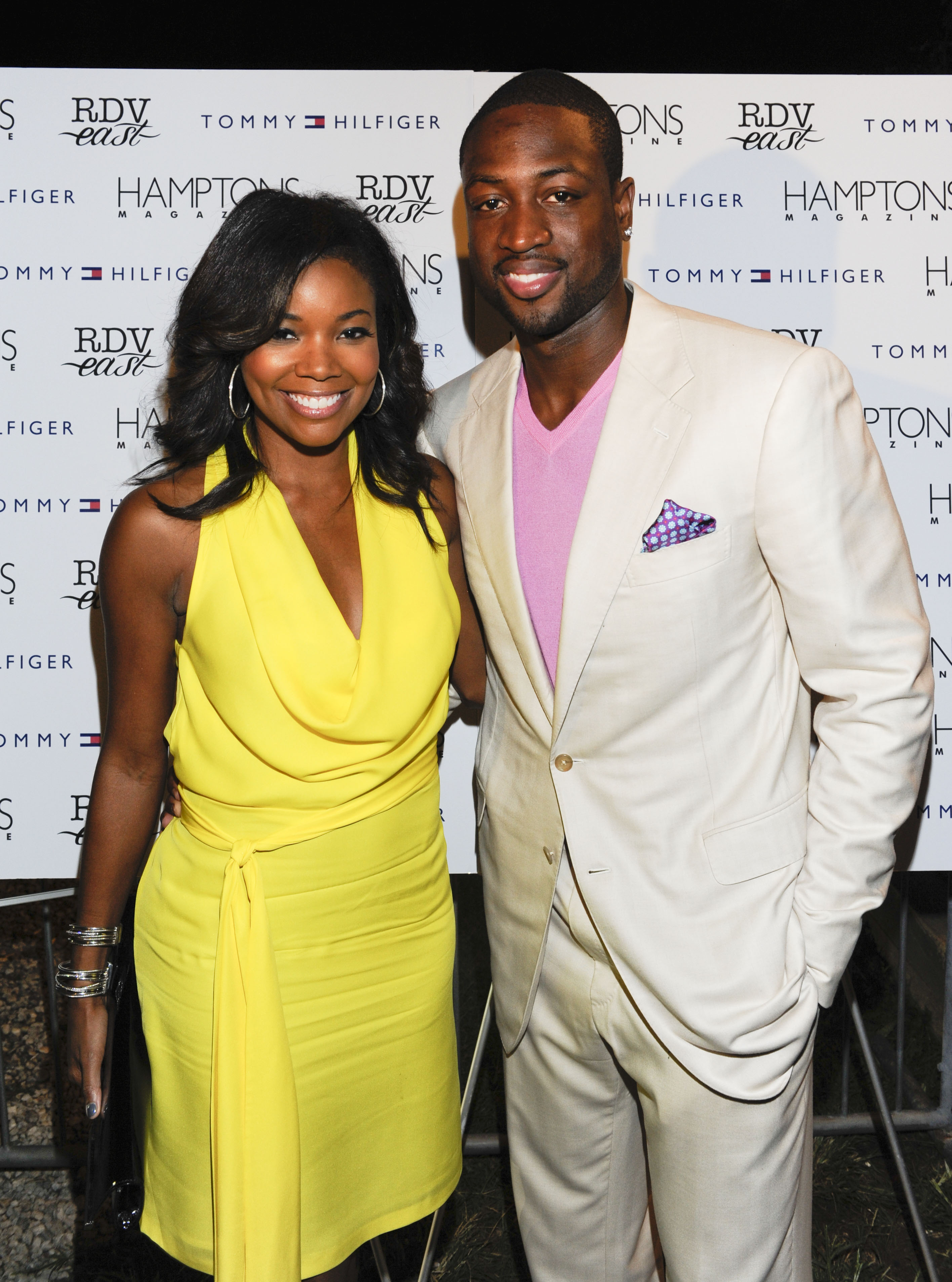 Gabrielle Union stands beside Dwyane Wade at an event, wearing a bright yellow dress, while he poses in a light-colored suit with a pink shirt; both smile at the camera. | Source: Getty Images