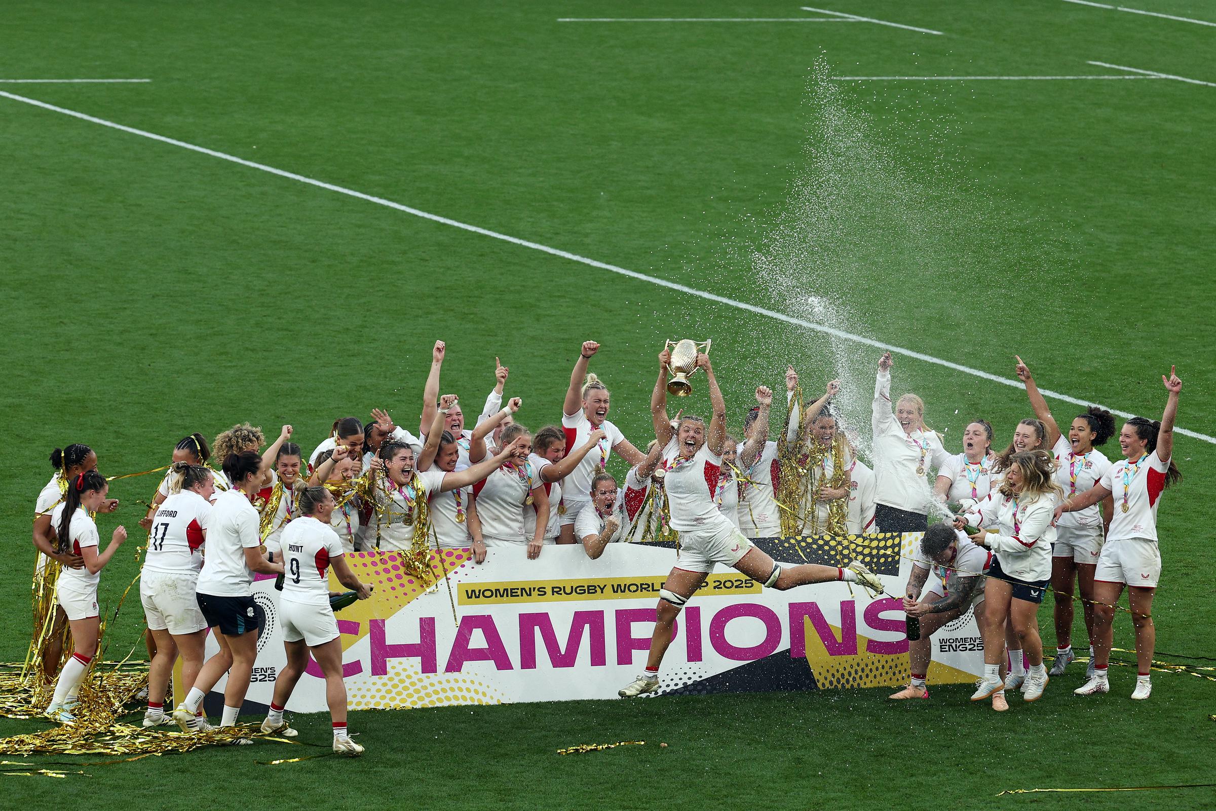 Zoe Aldcroft hoisting the trophy above her head as she and the Red Roses cheer loudly. | Source: Getty Images
