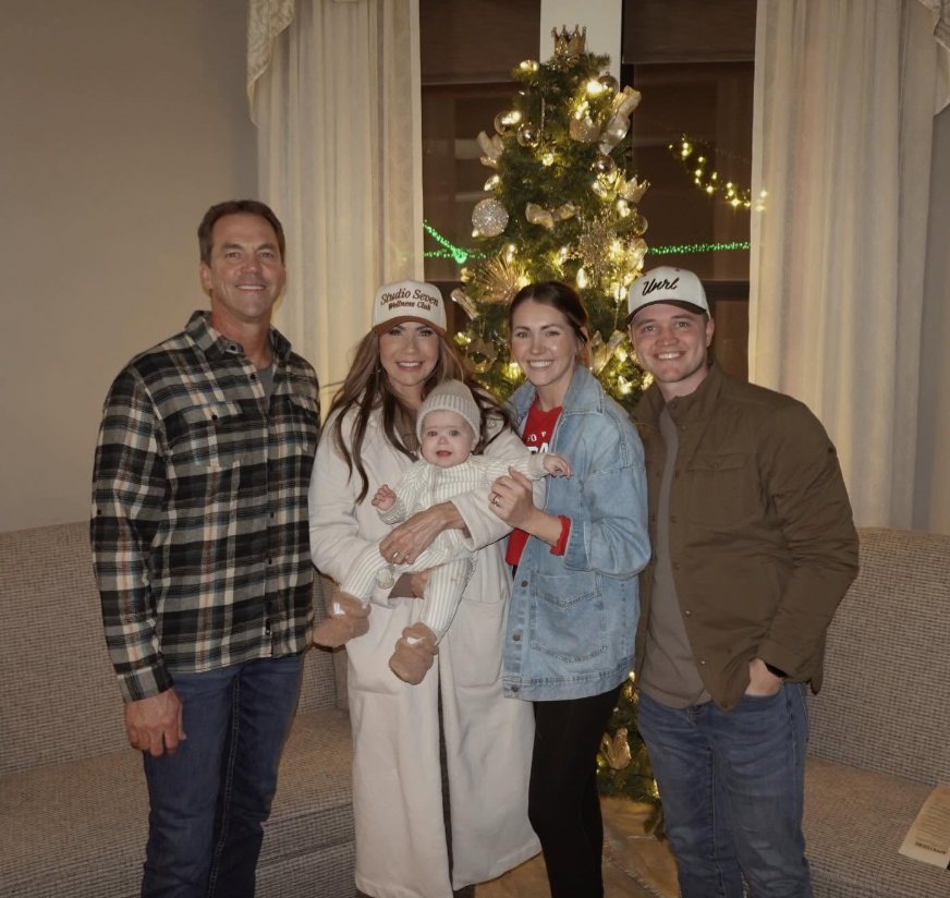 A Christmas gathering offers a wider look at the family's living area, where a decorated tree stands between tall windows and in front of a large sofa. The photo shows the room being used as a gathering place during the holidays. | Source: Facebook/kristi.noem