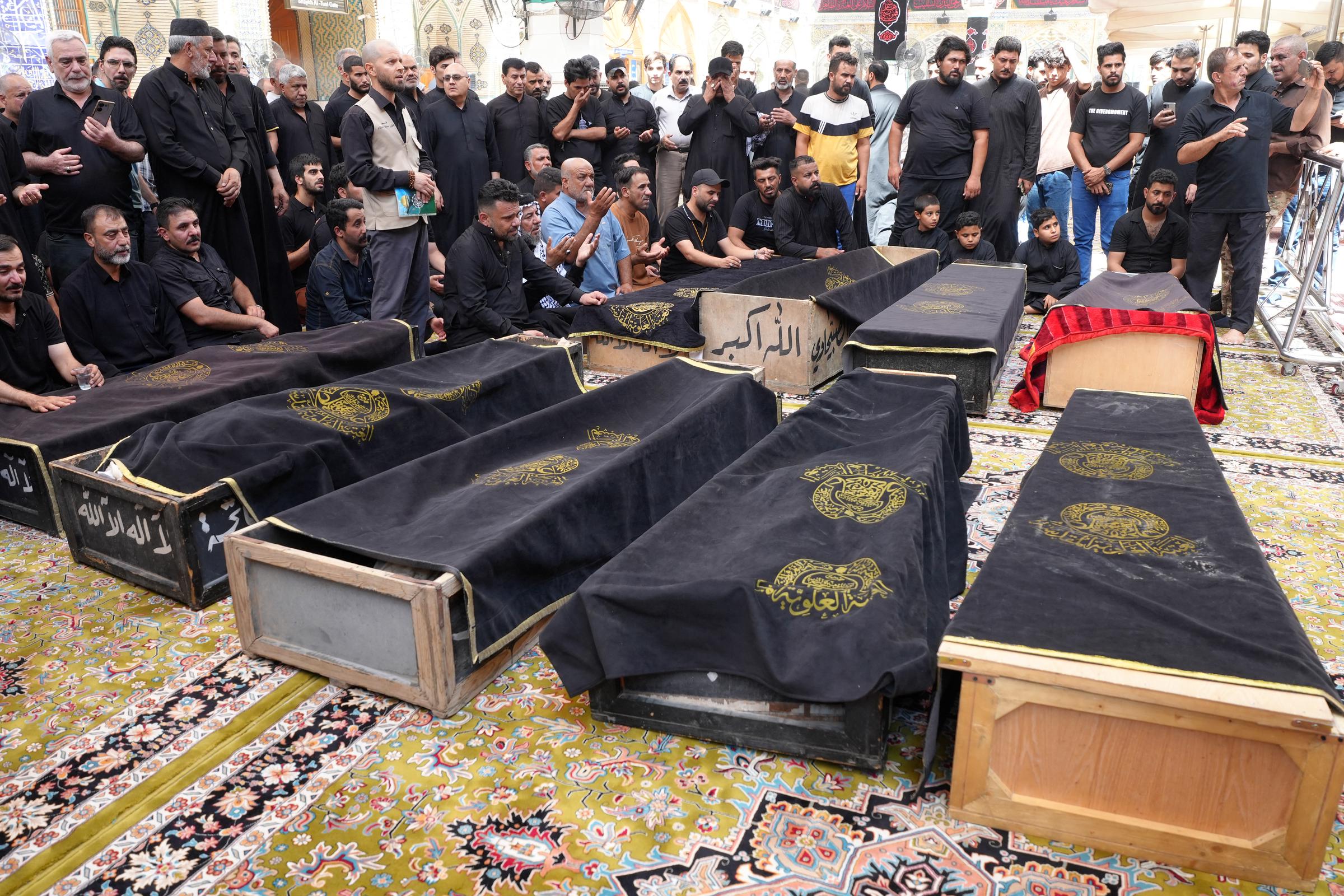 Dozens gather to mourn around the coffins of several victims of the Hyper Mall fire in Kut, Iraq on July 17, 2025. | Source: Getty Images