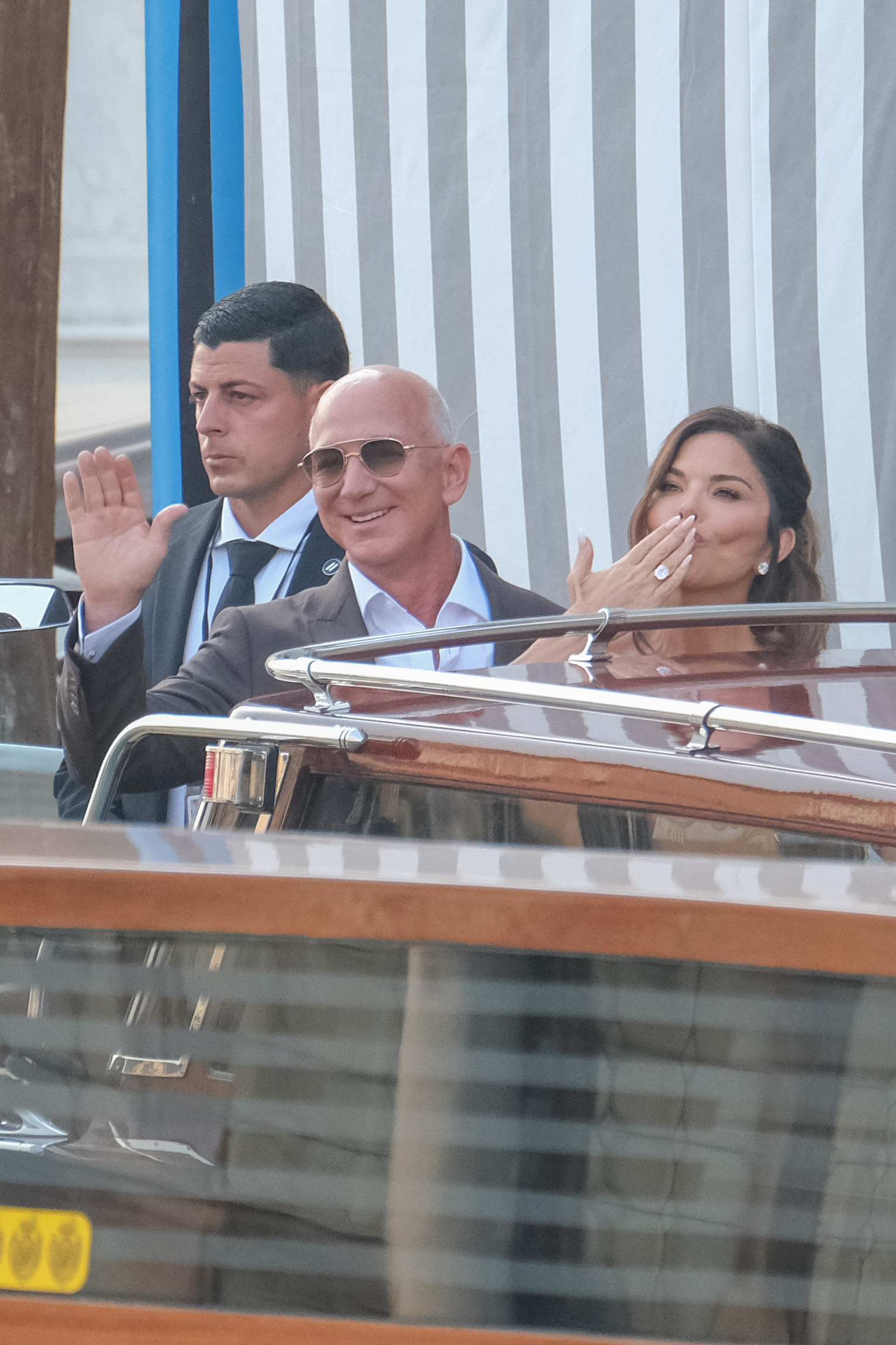 Jeff Bezos and Lauren Sánchez aboard a boat, with Sánchez blowing a kiss toward the crowd. | Source: Getty Images