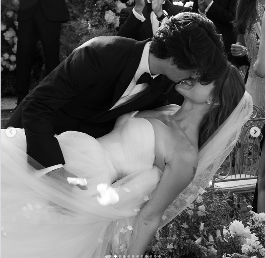 Dylan Lee dipped his bride backward for a kiss in a joyful black-and-white moment, with flower petals suspended in the air around her flowing veil. | Source: Instagram/stonedfinejewelry