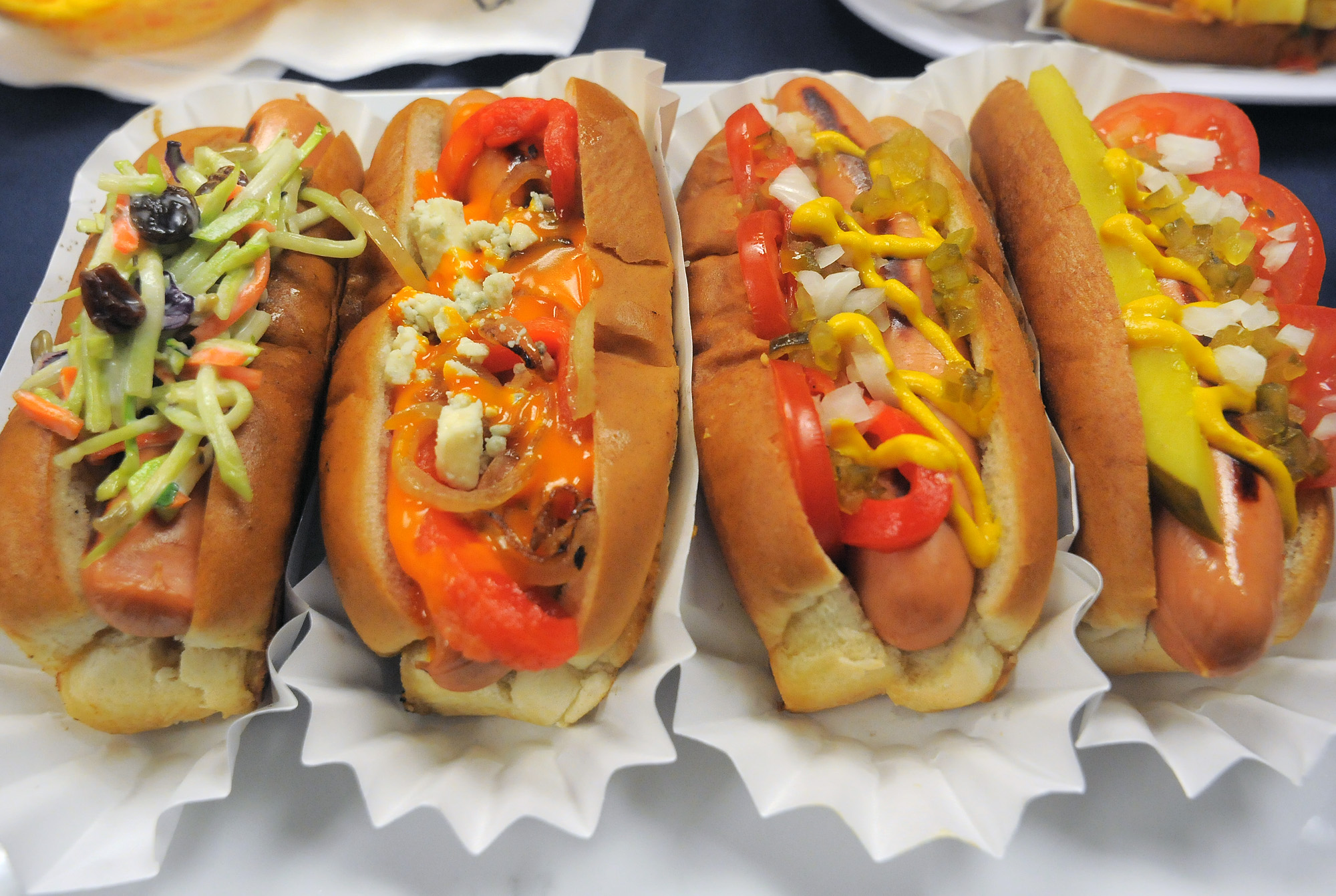 A selection of hot dogs topped with vegetables, mustard, cheese, and sauces showcases creations by Kayem product development chef Susanna Tolini inside the company's production facility. | Source: Getty Images