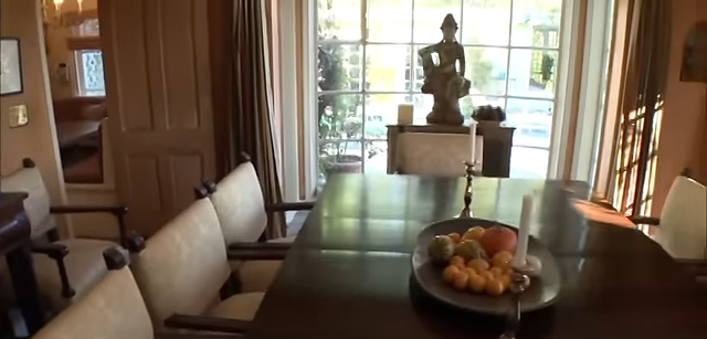 A Buddha statue sits in the window bay overlooking the patio, providing a tranquil backdrop for the dining room. | Source: YouTube/@Biography