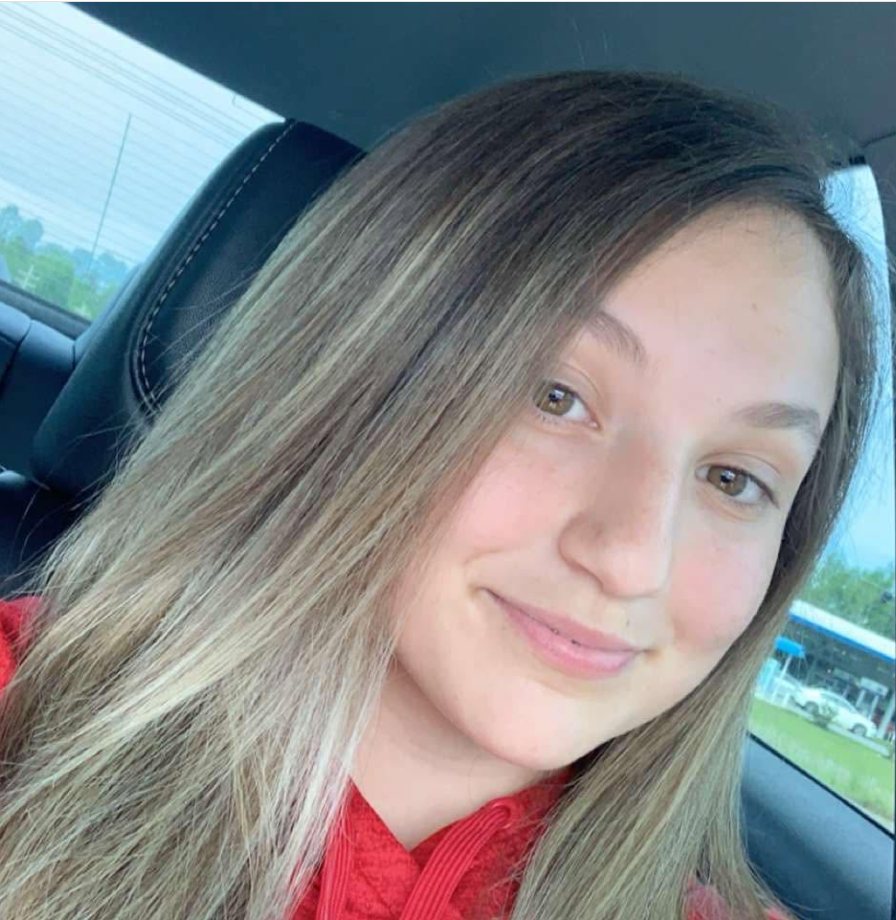 Wearing a red top, Katie McCormack poses for another car selfie with her hair falling over one shoulder. Officials are still seeking evidence that could clarify what happened on the island on July 4. | Source: Facebook/Katie McCormack
