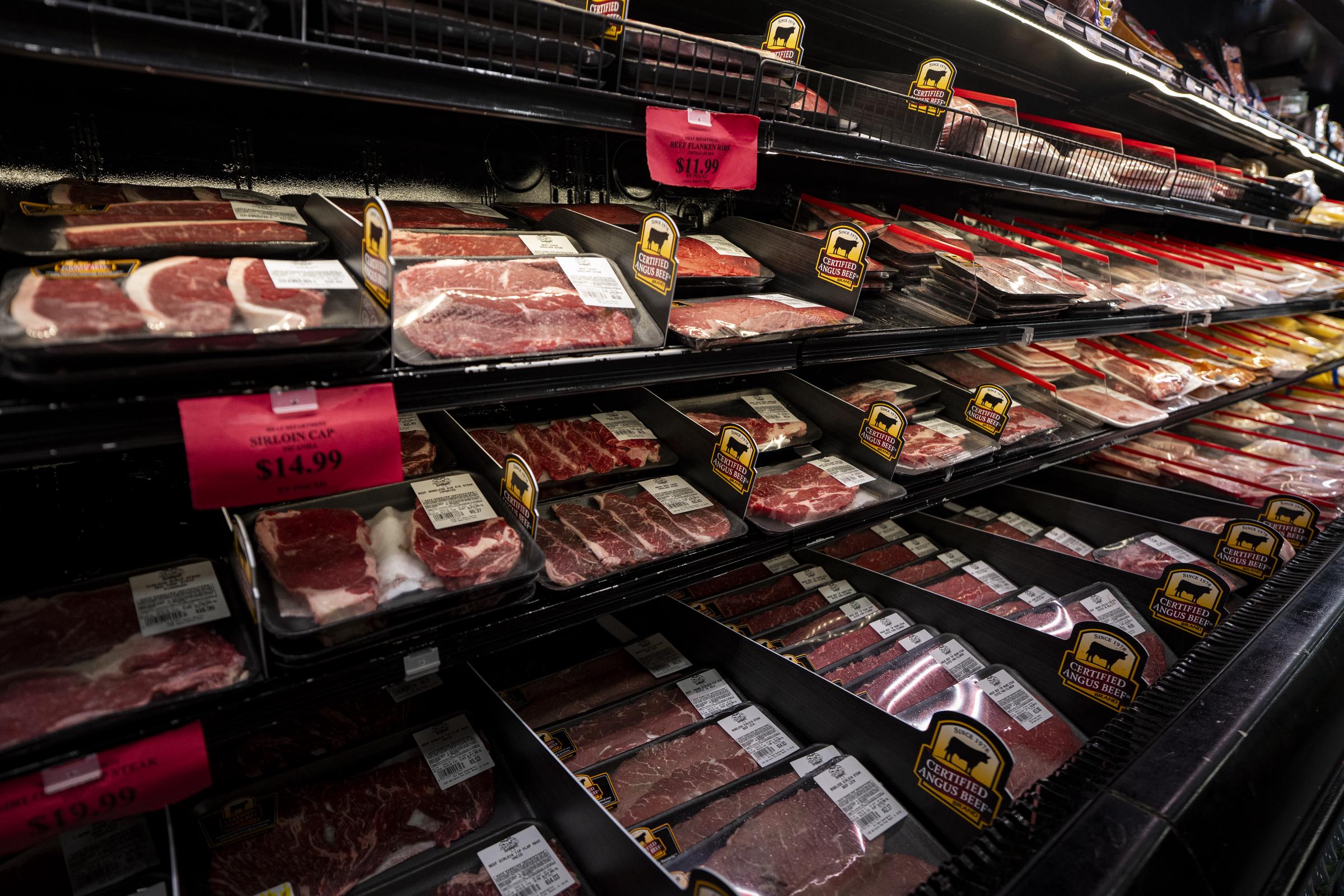 Fresh cuts of beef are displayed in wrapped trays beneath a supermarket's refrigerated "Beef" section. | Source: Getty Images