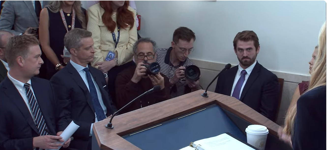 Reporters sit around the White House briefing table as Katie Zacharia takes questions during her first press briefing on October 13. | Source: YouTube/The White House