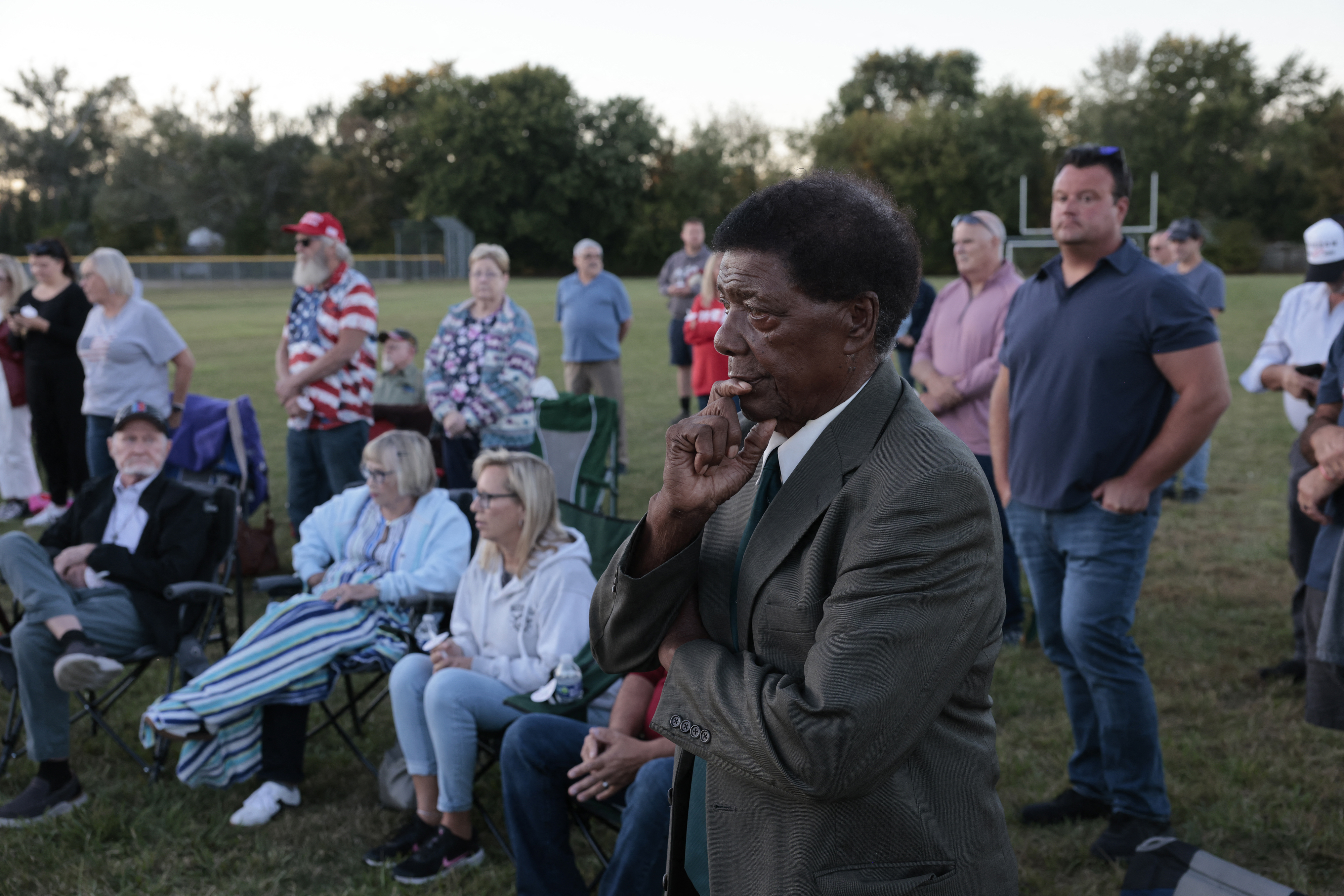 People at a prayer vigil led by Pastor Fr. Georges Bidzogo outside Holy Redeemer Church in Burton, Michigan, on September 28, 2025. | Source: Getty Images