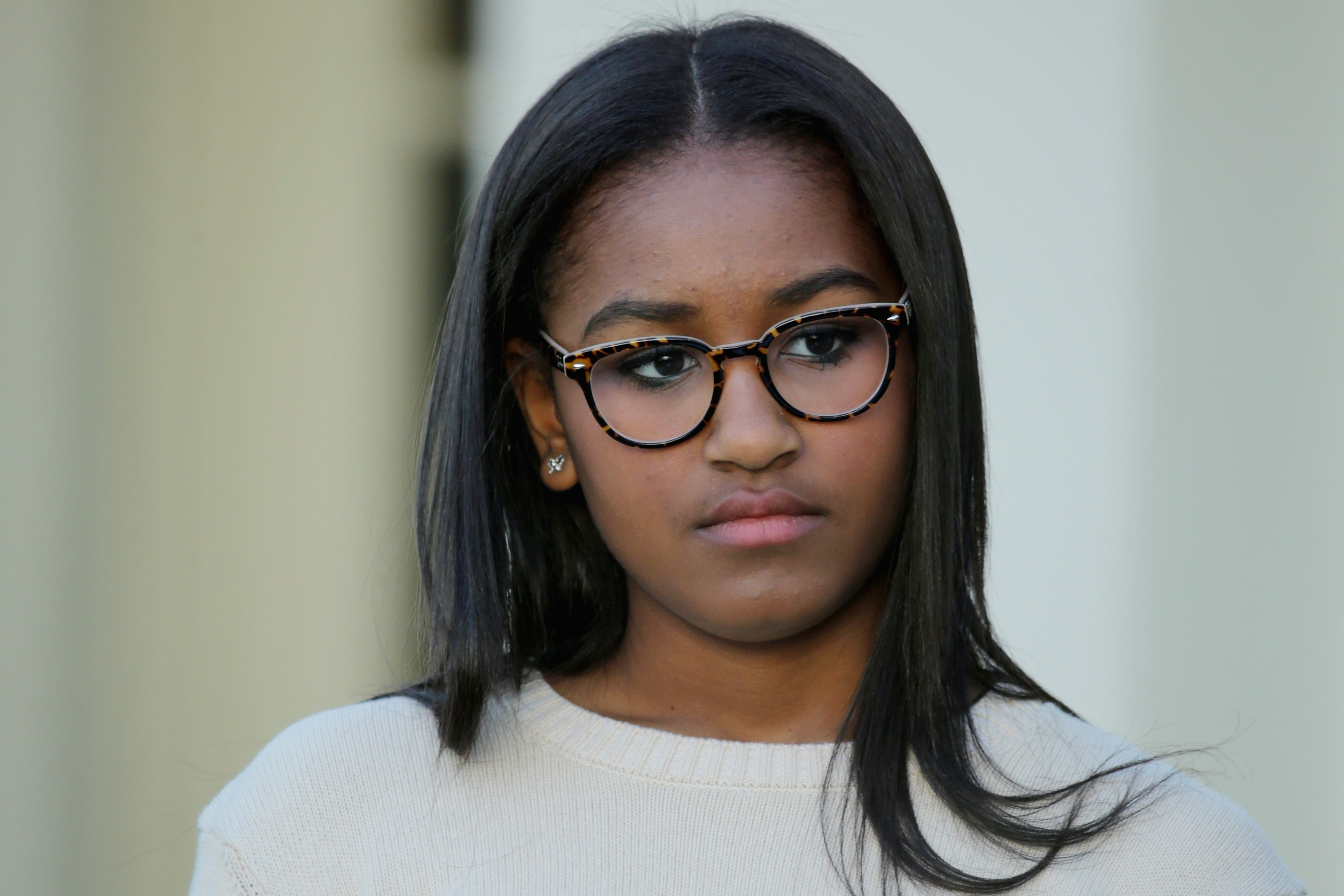 On November 25, 2015, in Washington, D.C., Sasha Obama, wearing glasses and a cream sweater, stood quietly in the Rose Garden as she took part in the annual turkey pardoning ceremony hosted by President Obama ahead of Thanksgiving.