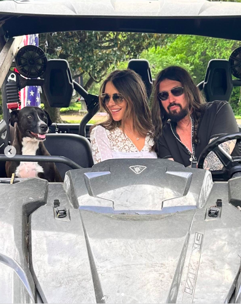 Elizabeth Hurley and Billy Ray Cyrus riding in a vehicle with a dog, posted on April 27, 2025. | Source: Instagram/elizabethhurley1