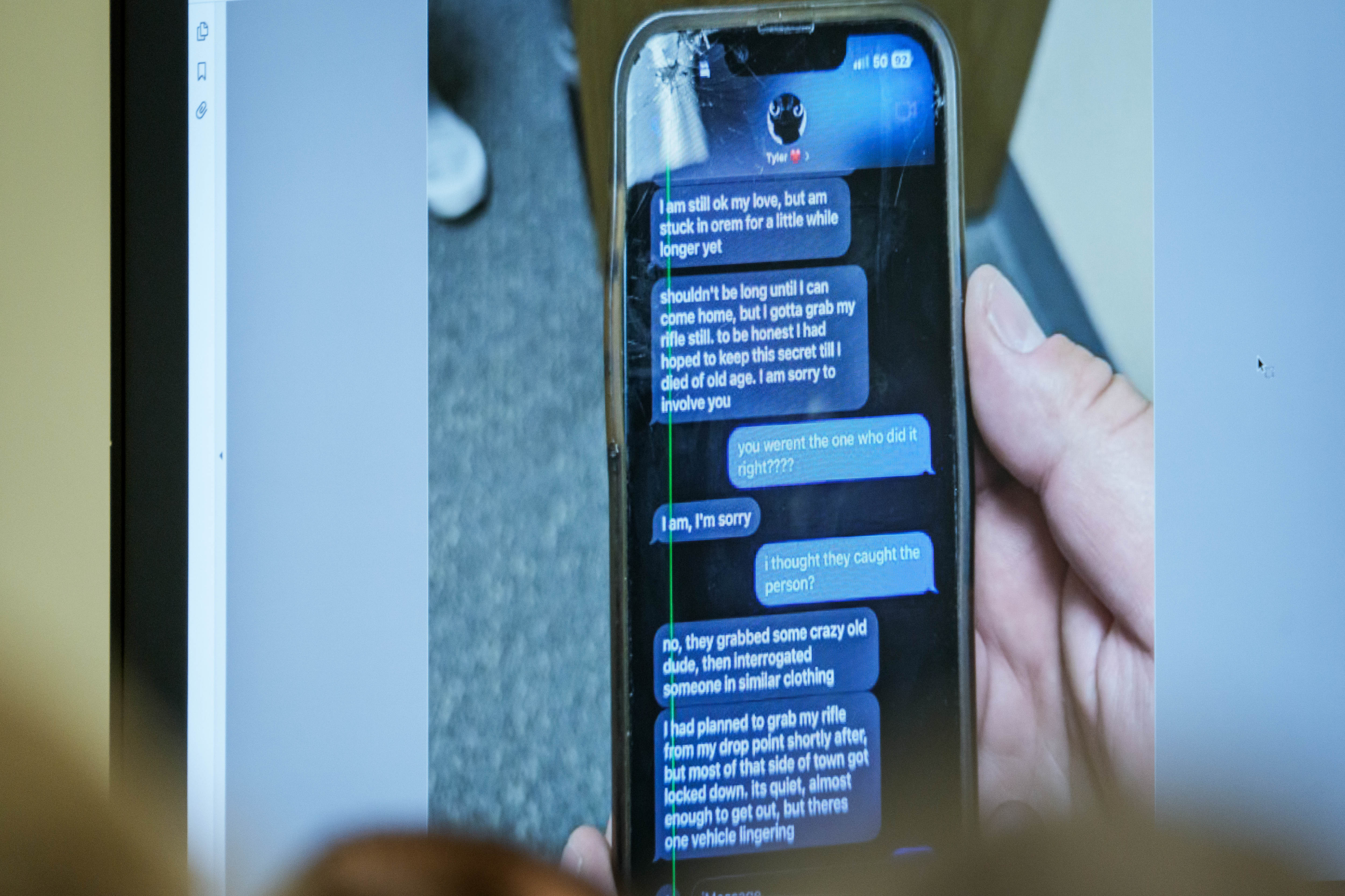 These text messages showed the defendant's alleged confessions regarding the shooting. In this photo, a photograph showing a text message exchange between Tyler Robinson and Lance Twiggs was displayed during a preliminary hearing at the Fourth District Courthouse on July 9, 2026, in Provo, Utah. | Source: Getty Images