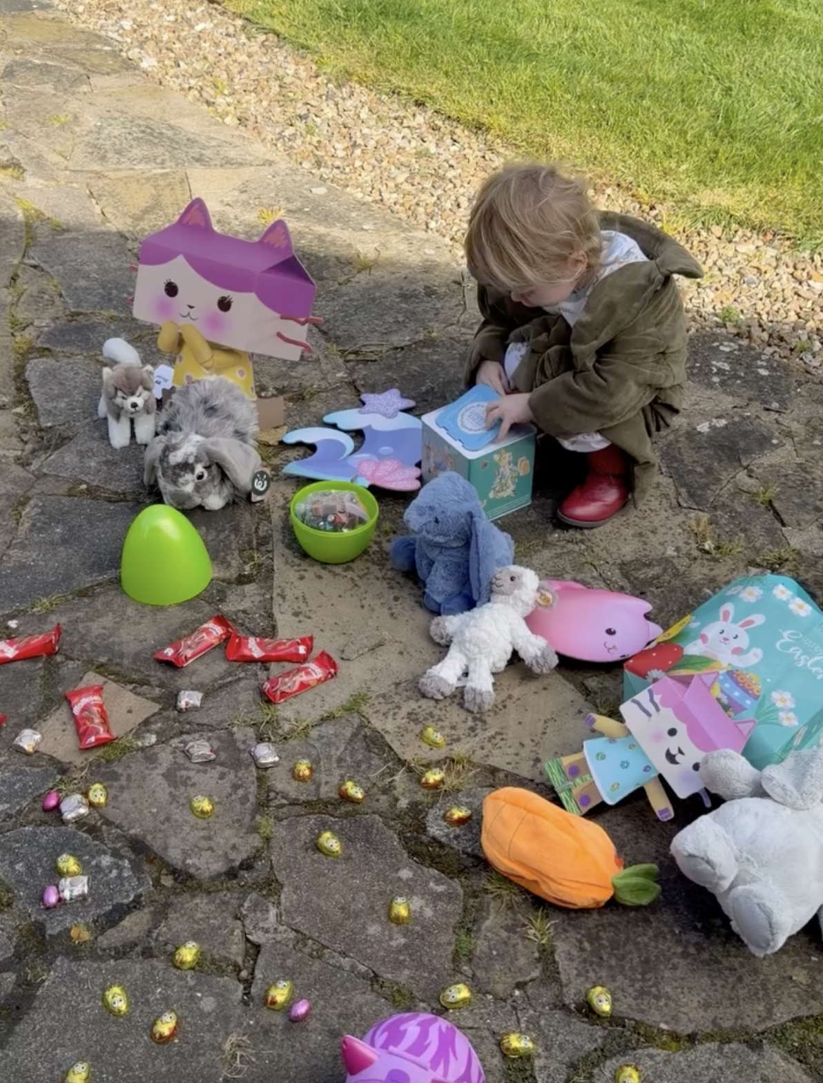 Kelly credited her mother with going all out to make Easter special. Sidney, dressed in a coat and red boots, explored a collection of stuffed animals, colorful eggs, and little gifts before carrying his basket indoors. | Source: Instagram/@kellyosbourne