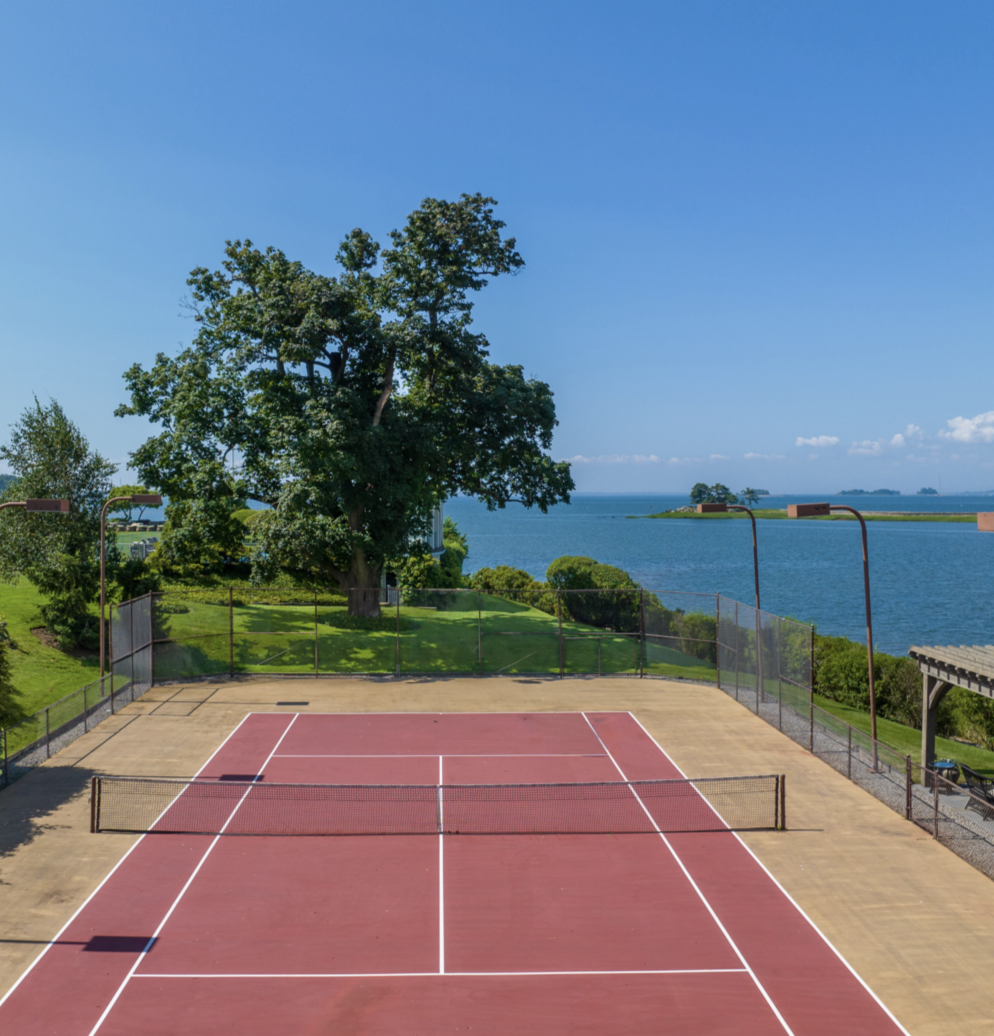 Cedar Cliff's private tennis court overlooks Long Island Sound, offering a spectacular waterfront setting for outdoor activities without ever leaving the estate. | Source: Instagram/@brizolisjanzen