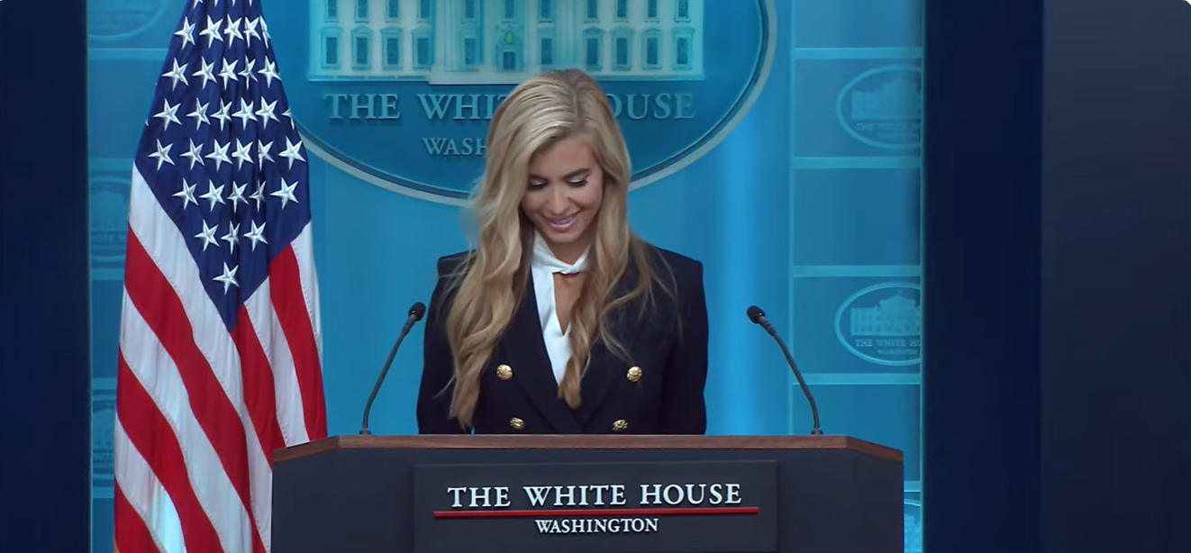 Katie Zacharia smiles while looking down at her notes during her first White House press briefing, as body language expert Dr. Lillian Glass later compared her delivery with that of her predecessor, Karoline Leavitt. | Source: YouTube/The White House
