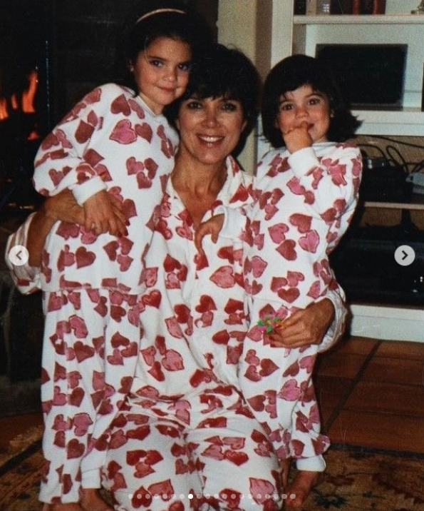 Kris Jenner poses with daughters in matching heart-patterned pajamas, holding both girls close for a playful family portrait. | Source: Instagram/krisjenner