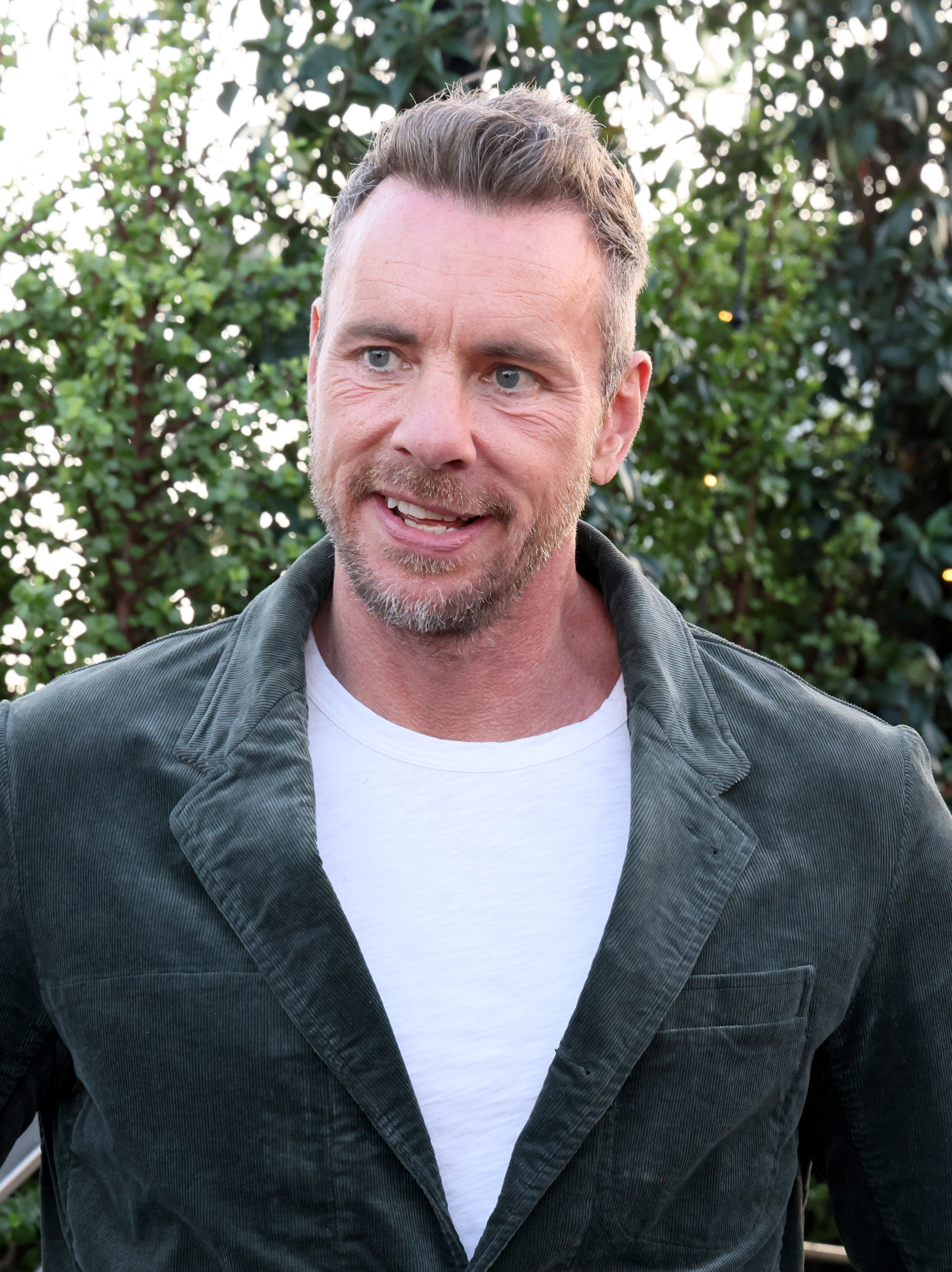 At a Variety podcast event, Dax Shepard keeps it cool in a forest green jacket and white tee. Against a leafy backdrop, he chats with ease, reflecting his growing role as a thoughtful voice in podcast culture.