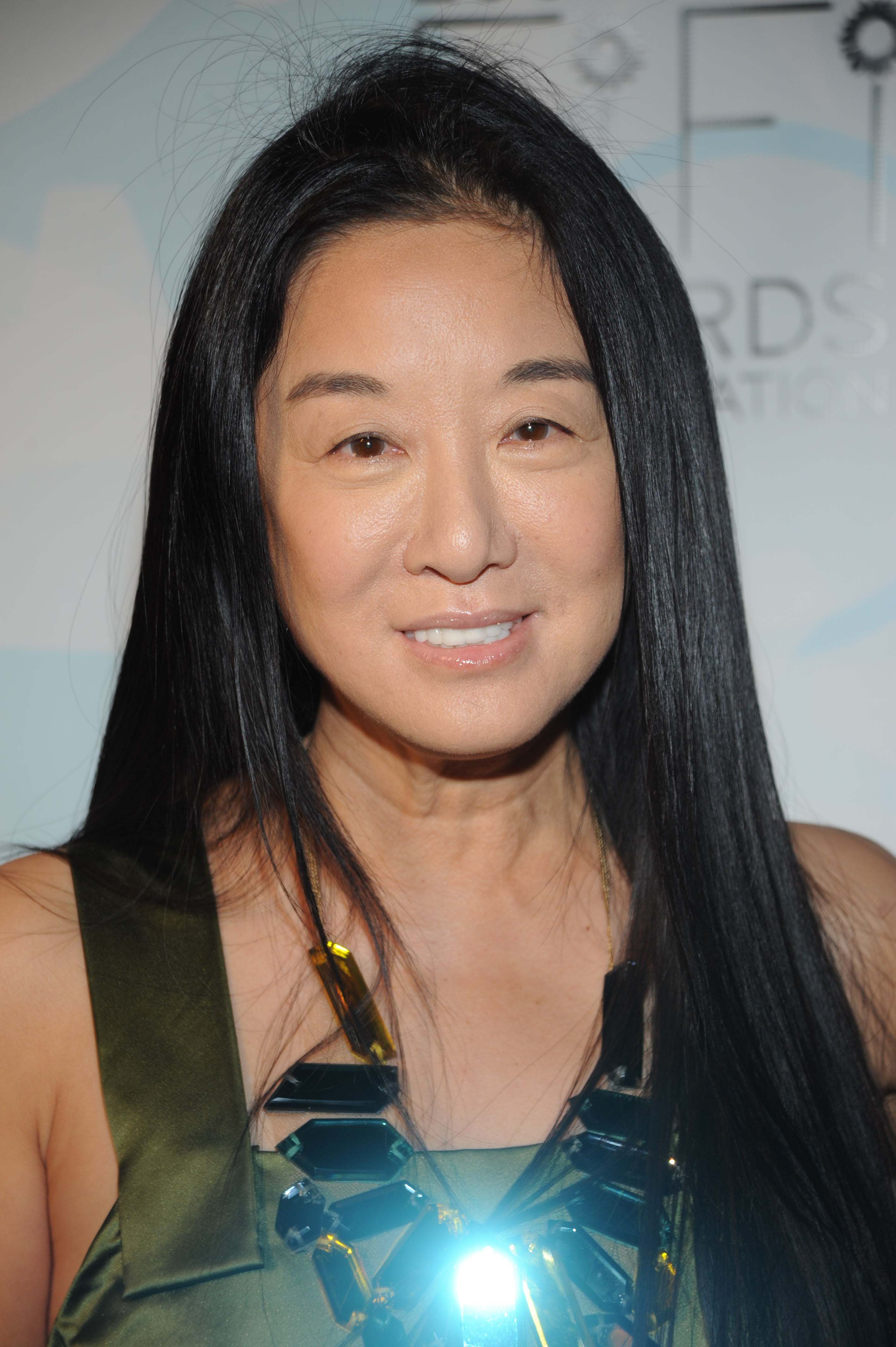 Vera Wang flashed a gentle smile during arrivals at the 36th Annual FiFi Awards at the Park Avenue Armory on May 20, 2008, in New York City. The designer complemented her sleek, center-parted raven locks with an olive-green satin dress and an eye-catching geometric faceted statement necklace. | Source: Getty Images